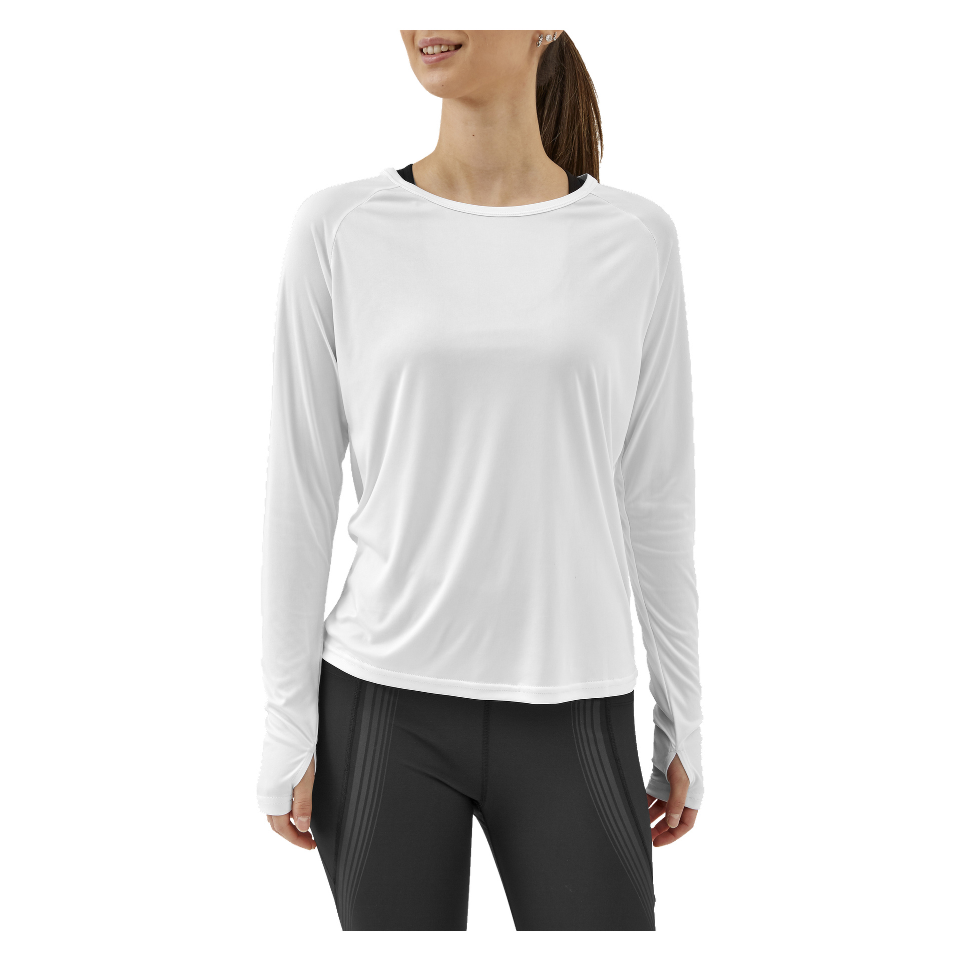 En kvinna i svarta leggings och Kayoba Women's Functional Top Atlanta står och tittar lite åt sidan med ett neutralt uttryck.