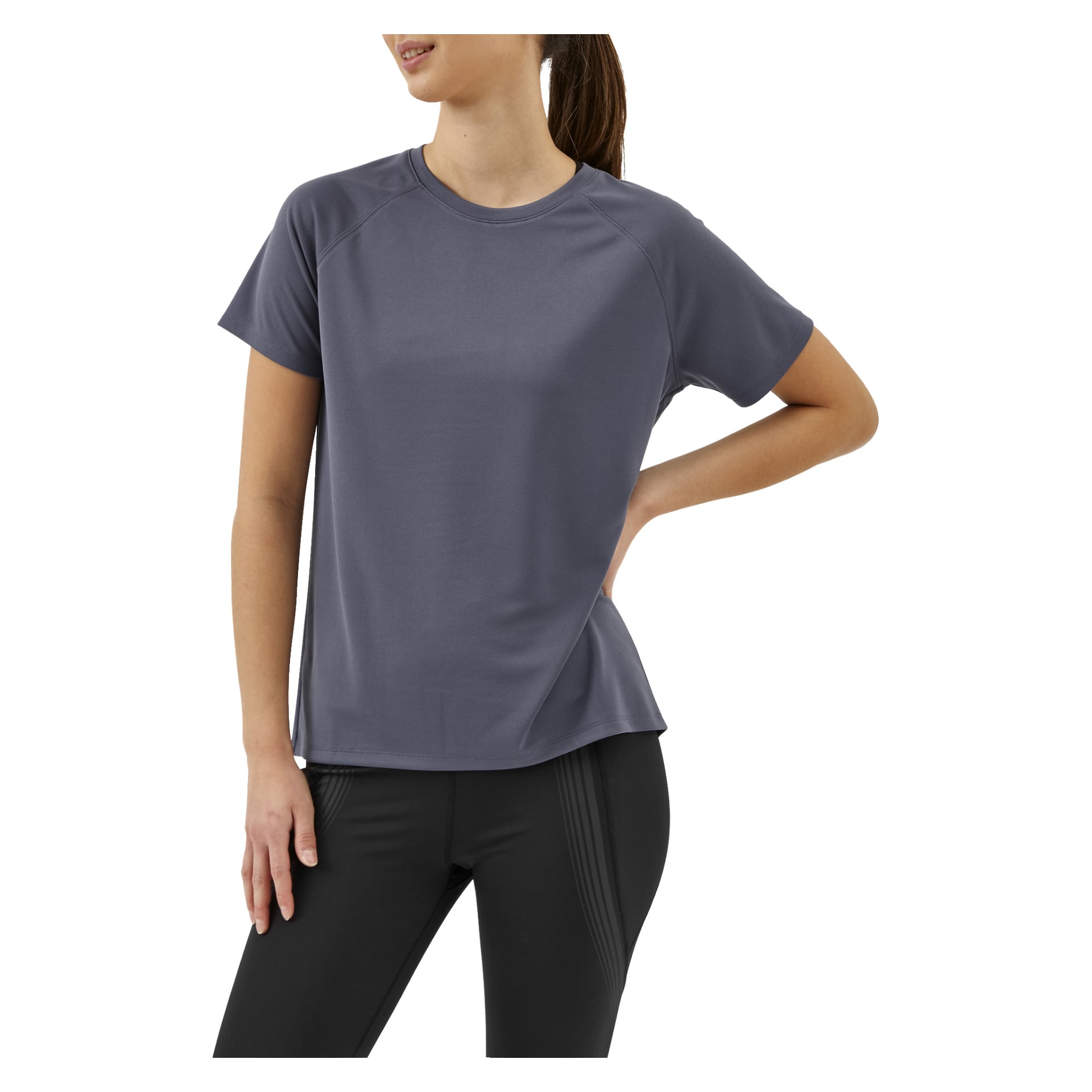 En kvinna modellerar Kayoba Women's Functional Top Tokyo, en grå kortärmad sporttröja samt svarta leggings, stående med ena handen på höften.