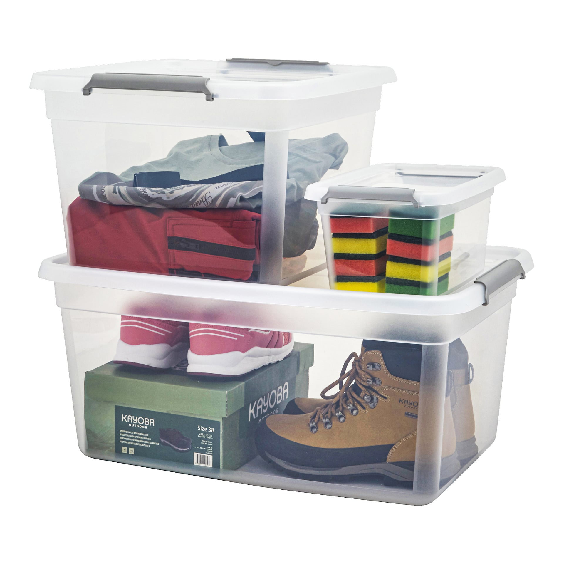 Tre Hard Head Storage-lådor med lock är staplade ovanpå varandra. Inuti lådorna kan du se vikta kläder, röda sneakers, bruna stövlar, skokartonger och en mängd färgglada rengöringssvampar.