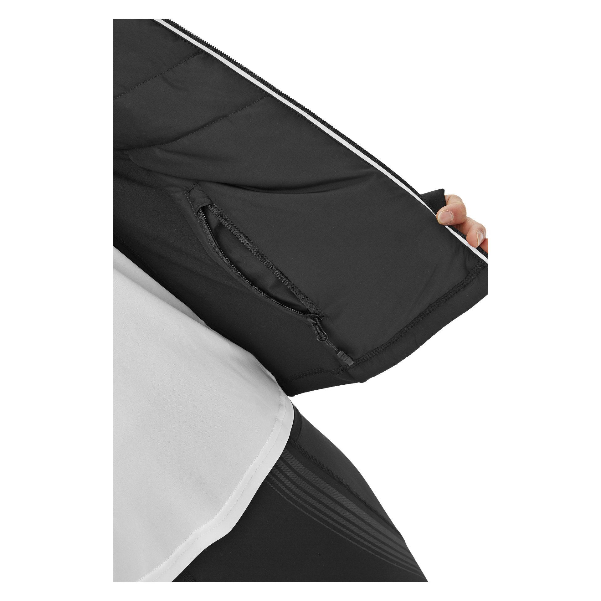 Eine Frau in einem weißen Hemd und schwarzen Hosen zeigt die umkehrbare Kayoba Women's Runningjacke Innsbruck in Schwarz und zeigt die mit Reißverschluss verschlossene Innentasche.
