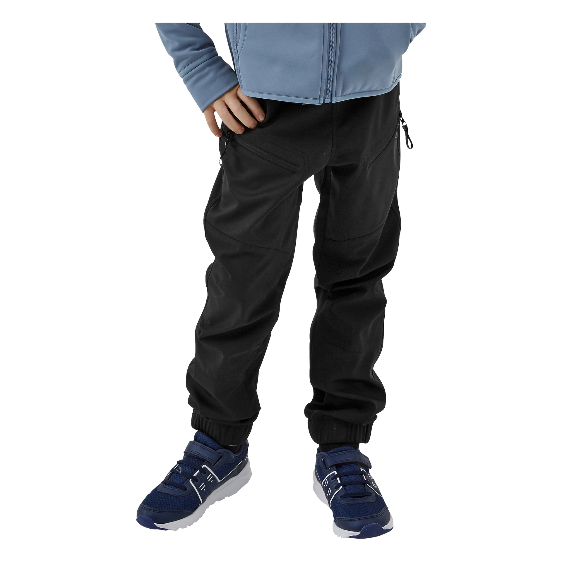 Ein Kind modelliert Kayoba Outdoor-Kinderhosen mit Reißverschlusstaschen und posiert mit einer Hand in der Hüfte. Der Look wird kombiniert mit einer hellblauen Jacke und blauen Sneakern mit weißen Sohlen.