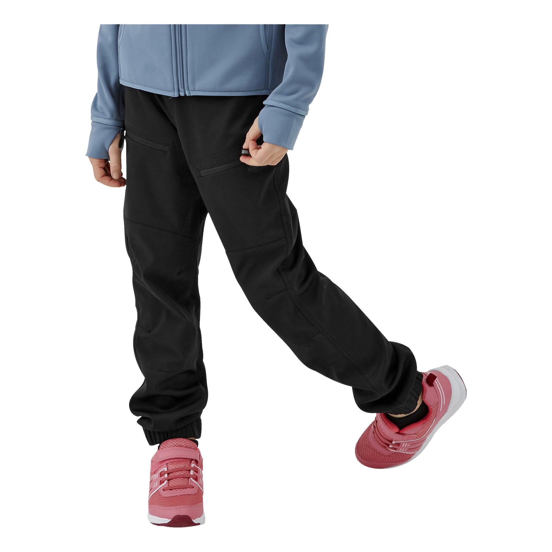 Ein Kind präsentiert die Kinderhose von Kayoba Outdoor, eine hellblaue Jacke und knallpinke Turnschuhe, steht mit einem Bein lässig über das andere geschlagen.