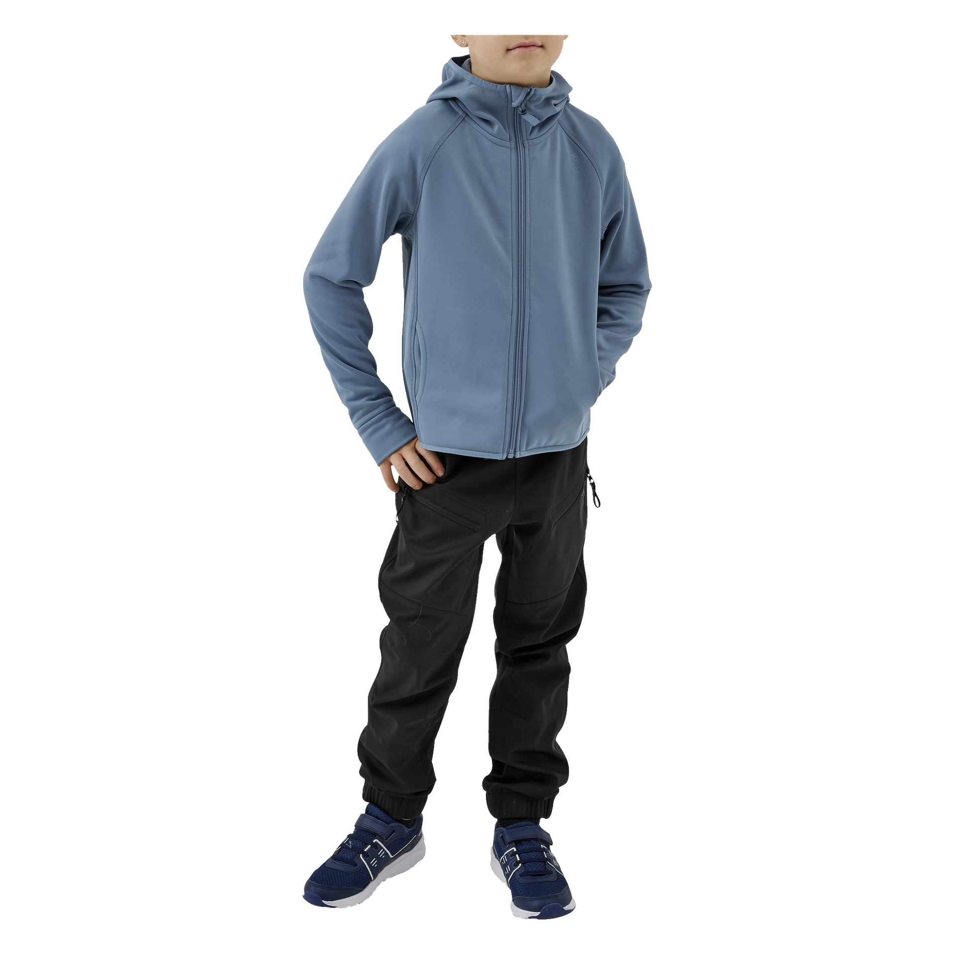 Ein Kind posiert mit einer Hand in der Hüfte, gekleidet in Kayoba Outdoor-Kinderhosen, eine hellblaue Kapuzenjacke und blaue Sportschuhe mit weißen Sohlen. Das Gesicht ist teilweise verdeckt.