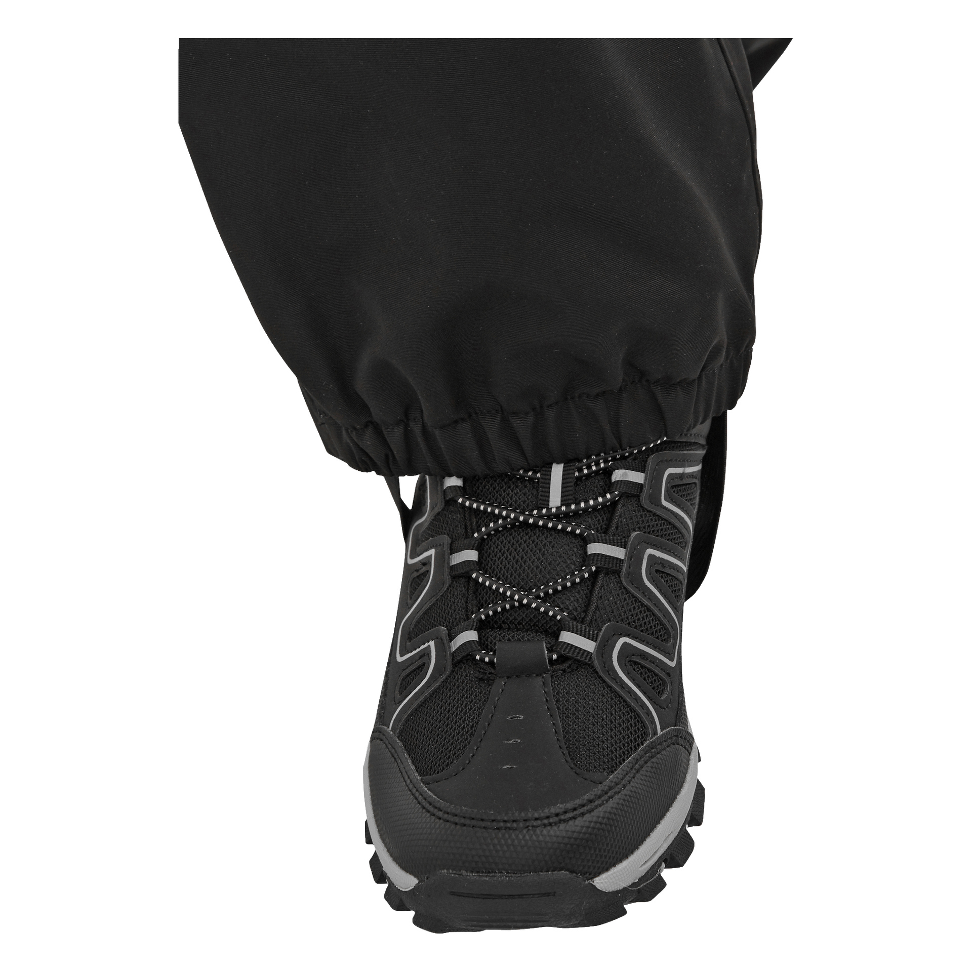 Eine Nahaufnahme der schwarzen Überhose von Kayoba Outdoor Children, die einen elastischen Ärmel über einen schwarzen Wanderschuh mit grauen Details zeigt. Die Hose wird am Fuß getragen.