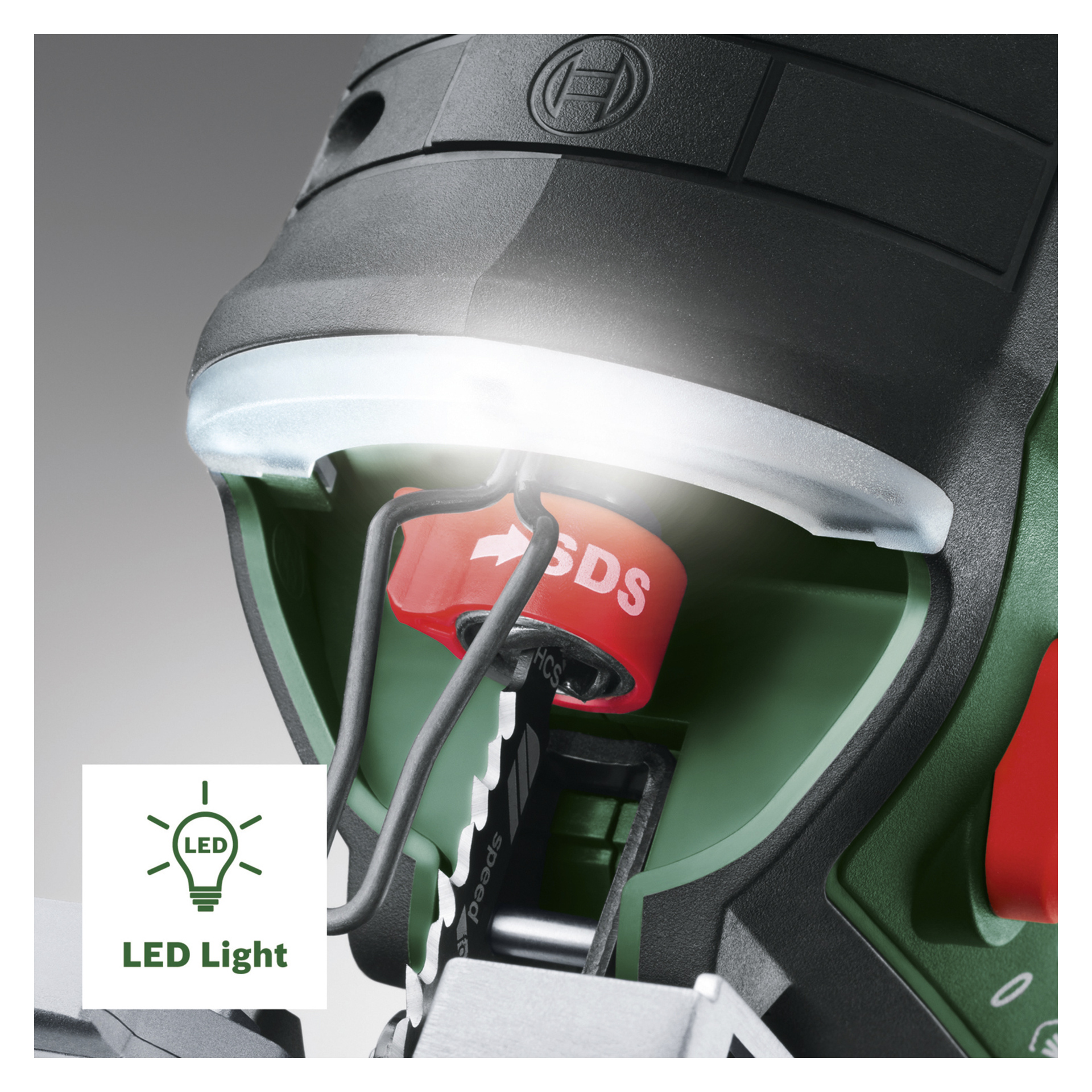 Bosch Power 4 All AdvancedSaw 18V-140 batteripuslespillet vises i nærbilde, og fremhever et opplyst LED-lys over arbeidsområdet. Verktøyets design inkluderer et karakteristisk rødt SDS-element og et eksponert blad i det grønne og svarte hylstret. Et LED-lysikon og en etikett vises nederst til venstre.