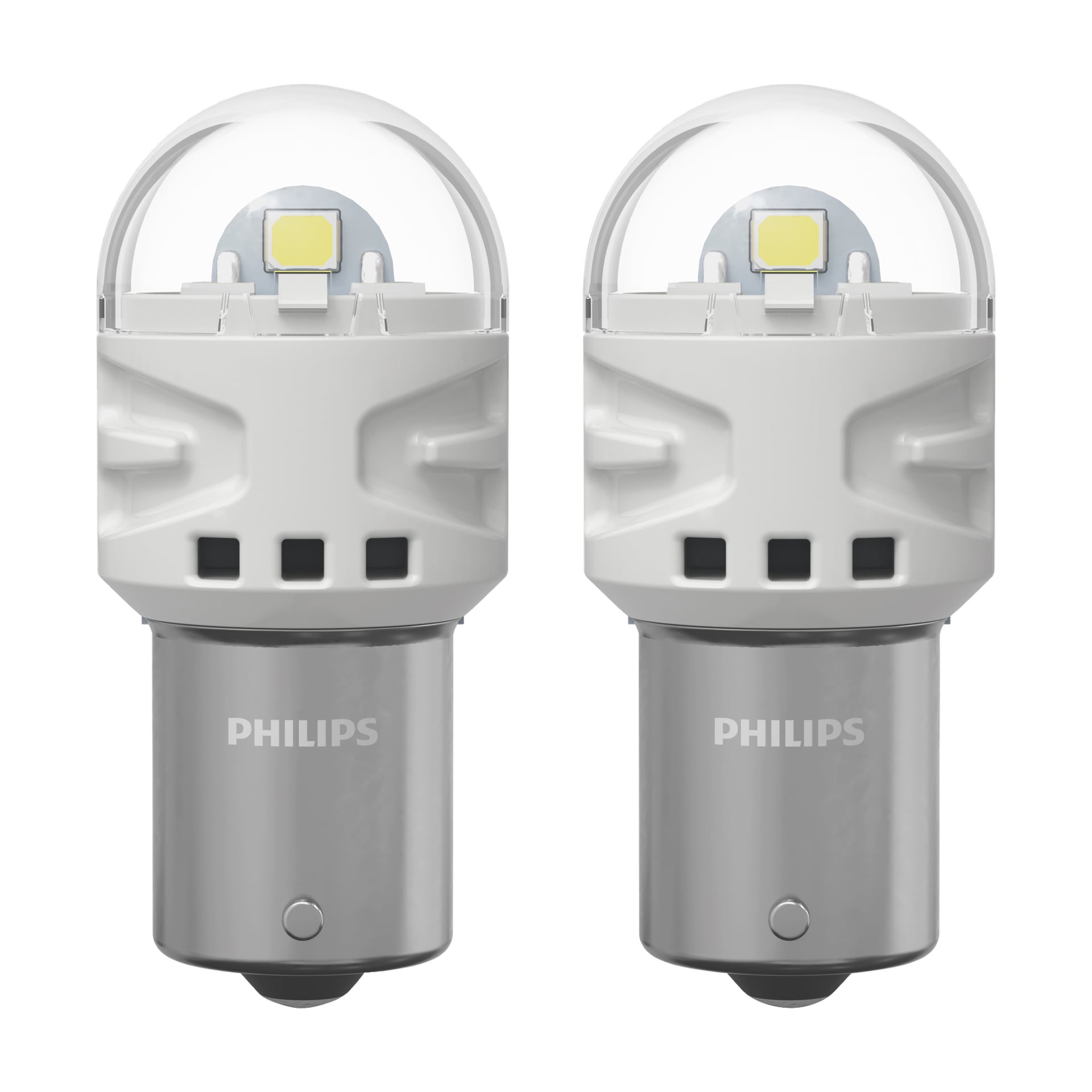 Pari Philips Ultinon Pro3100 -ajovalolamppua on esillä vierekkäin, joissa on tyylikäs valkoinen ja hopeinen pinta, pyöristetyt läpinäkyvät yläosat ja näkyvä LED-siru. Molempien lamppujen metallipohjassa on Philipsin logo.