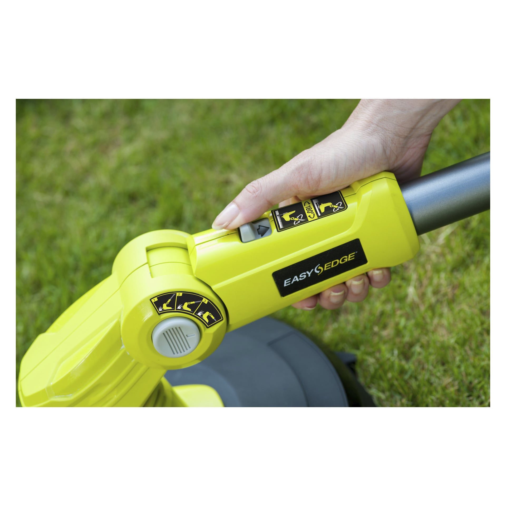 En hand trycker på en knapp på den gula Ryobi One+ RLT183240F batteridriven grästrimmer, märkt med "EasyEdge" och flera instruktionsklistermärken, medan den står på en gräsmatta.