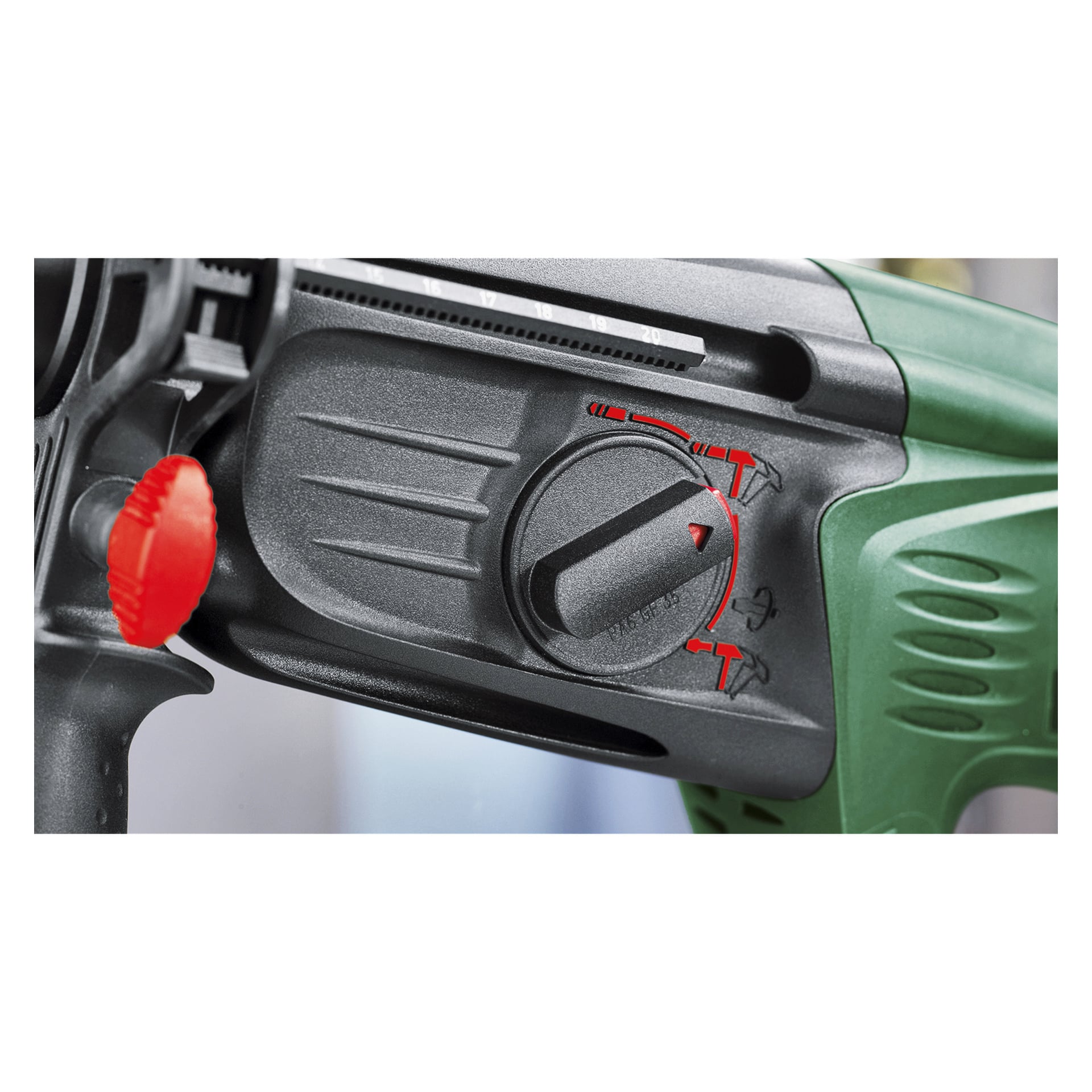 Nahaufnahme eines Bosch Hammer-Bohrers PBH 2800 RE, grün und schwarz gefärbt, mit einem deutlich sichtbaren schwarzen Moduswahlrad mit roten Markierungen, einem roten Pfeilanzeiger und einem strukturierten roten Einstellknopf auf der linken Seite des Griffs.