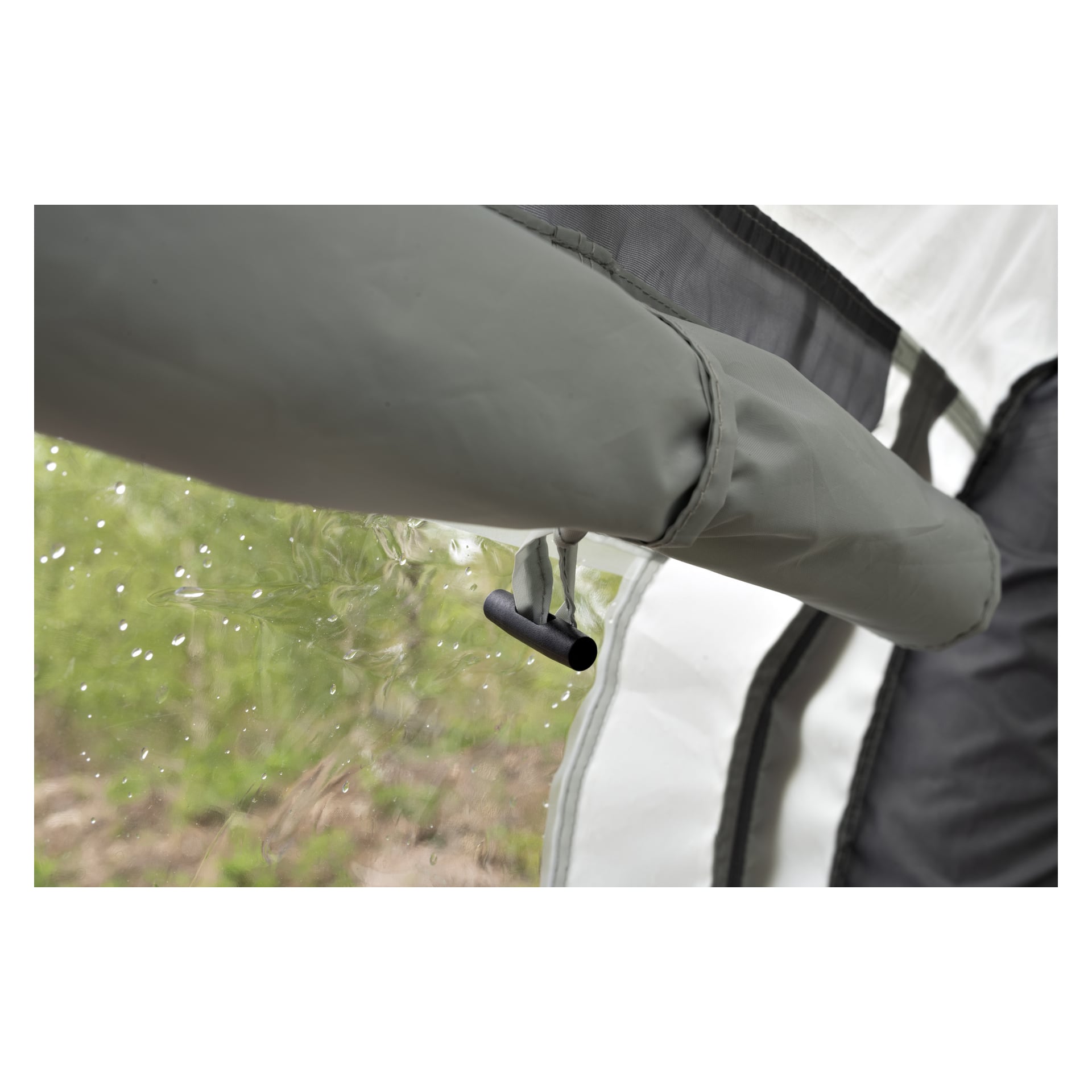 Lähikuva ilmaventtiilistä Kayoba Air -markiisissa asuntovaunu- tai matkailuautossa. Vesipisarat näkyvät läpinäkyvässä ikkunassa, ja tausta on pehmeä, sumea vihreä.
