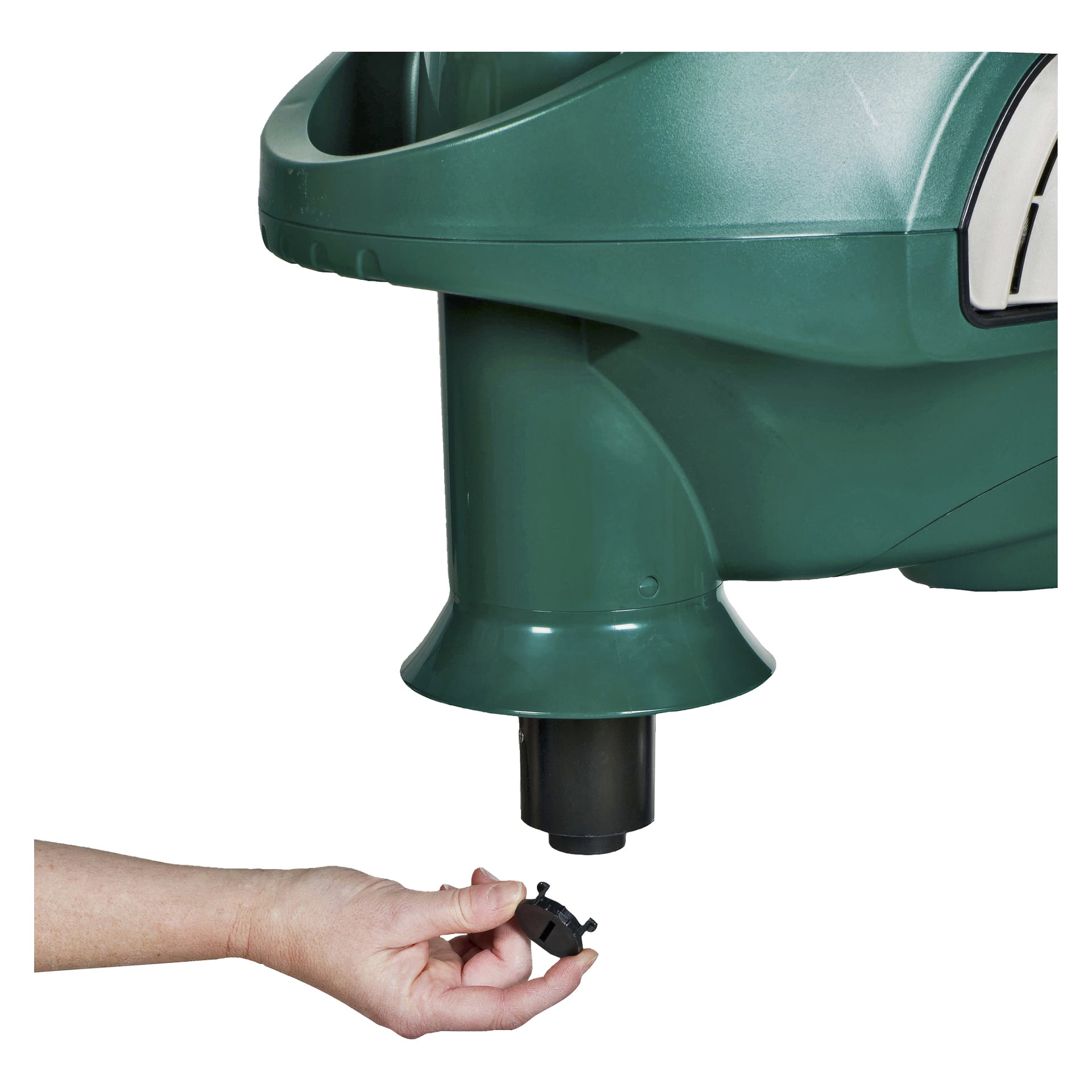 En hand håller en liten rund plugg under avloppsröret på en stor grön plastmyggfälla Mosquito Magnet Pioneer med gas. Kontakten är avsedd att passa i öppningen vid enhetens bas.