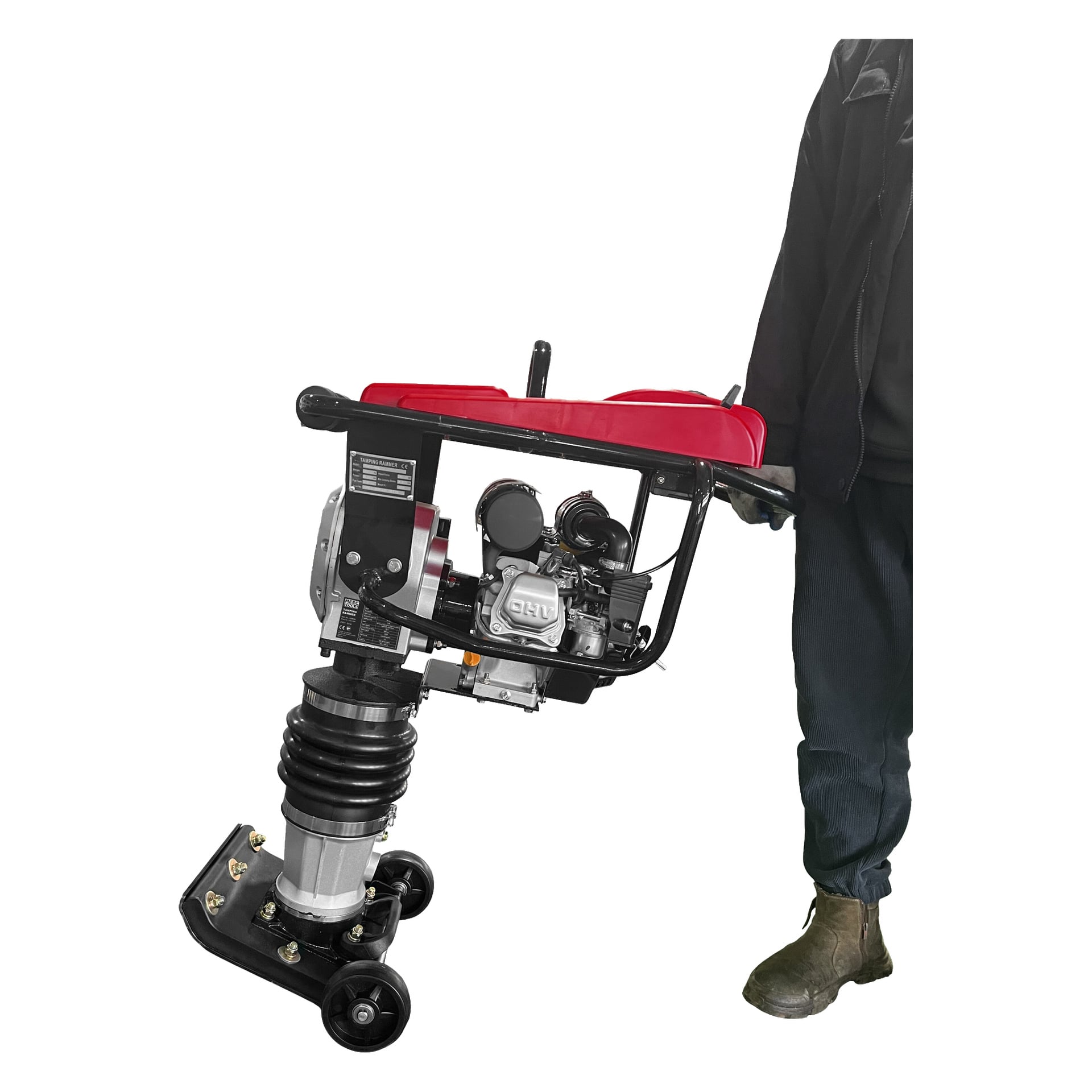 Tummiin vaatteisiin pukeutunut henkilö pitää kädessään Meec Tools Vibration -levyä, jossa on mustat kahvat, näkyvä jousimekanismi sekä punaiset ja hopeiset yksityiskohdat. Laite on kyljellään, näyttäen pyörät alhaalla.