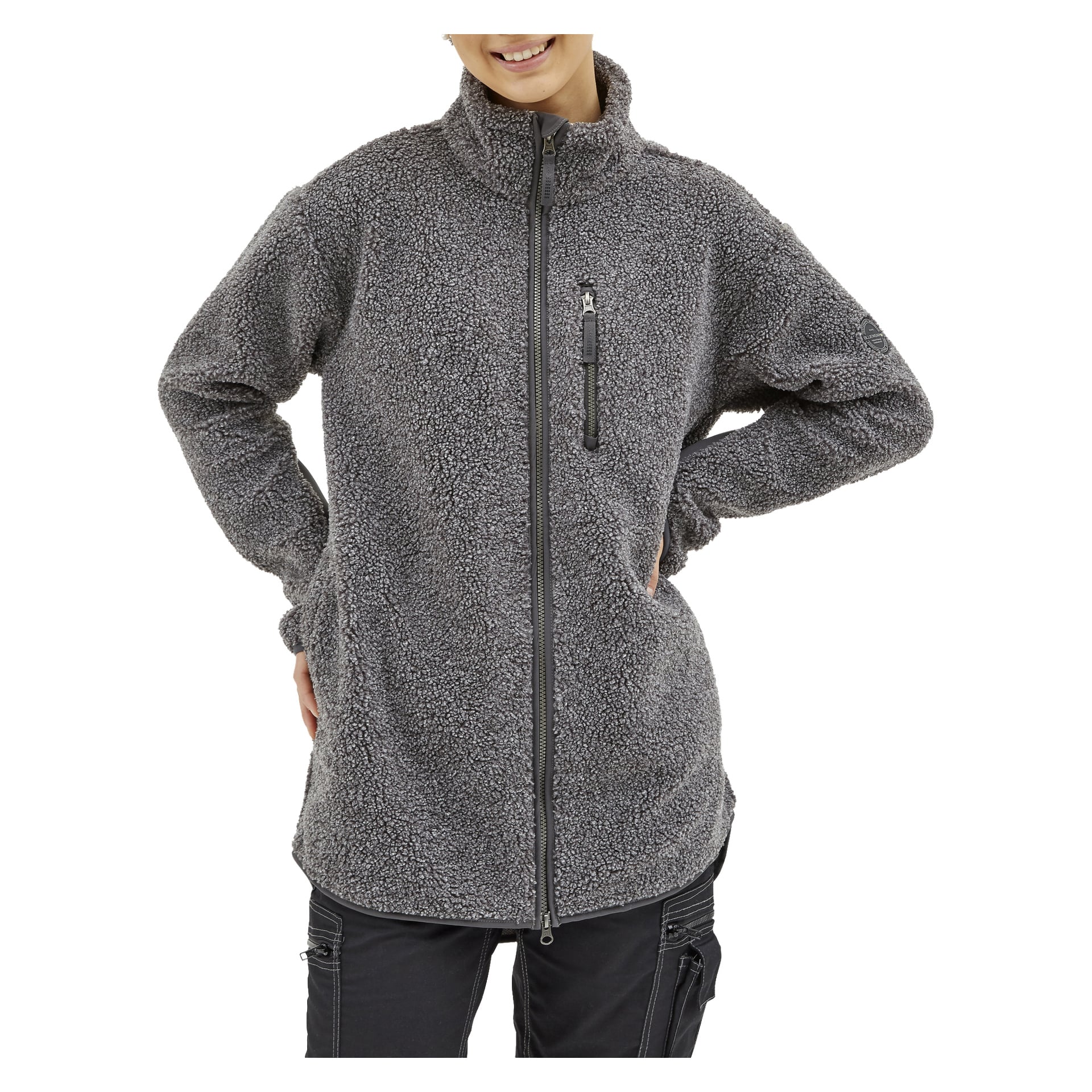 Man trägt die Bluewear Vivienne Damenfleecejacke in Grau, die einen hohen Kragen und eine Reißverschlusstasche an der Brust hat. Sie haben die Hände in die Hüften.