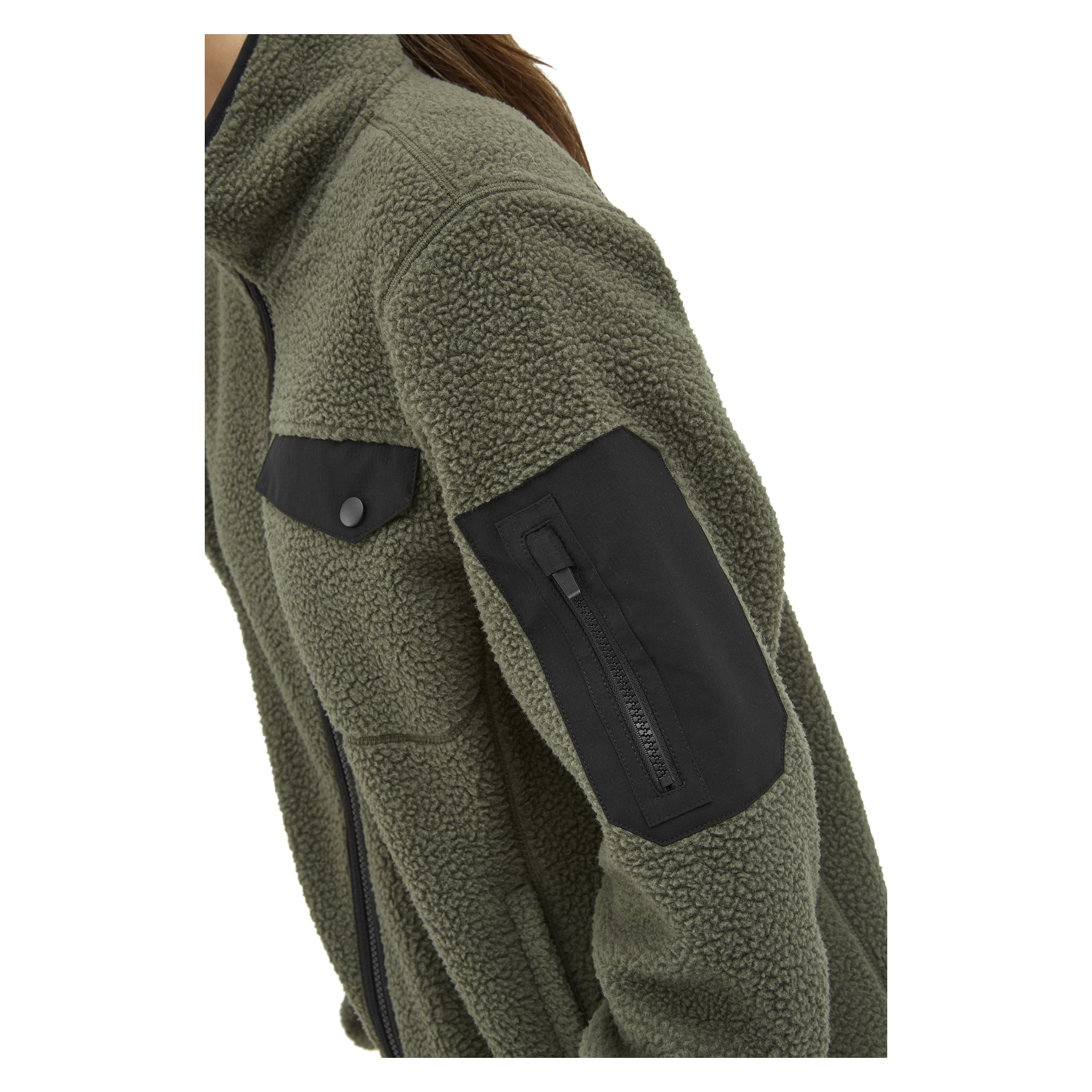 Eine Nahaufnahme zeigt jemanden in der Kayoba Outdoor Woman's Fleecejacke Ljusdal, olivgrün, mit einem schwarzen Aufnäher und einer Reißverschlusstasche am Oberarm sowie einer Brusttasche, die mit einer schwarzen Druckknöpfklappe gesichert ist.