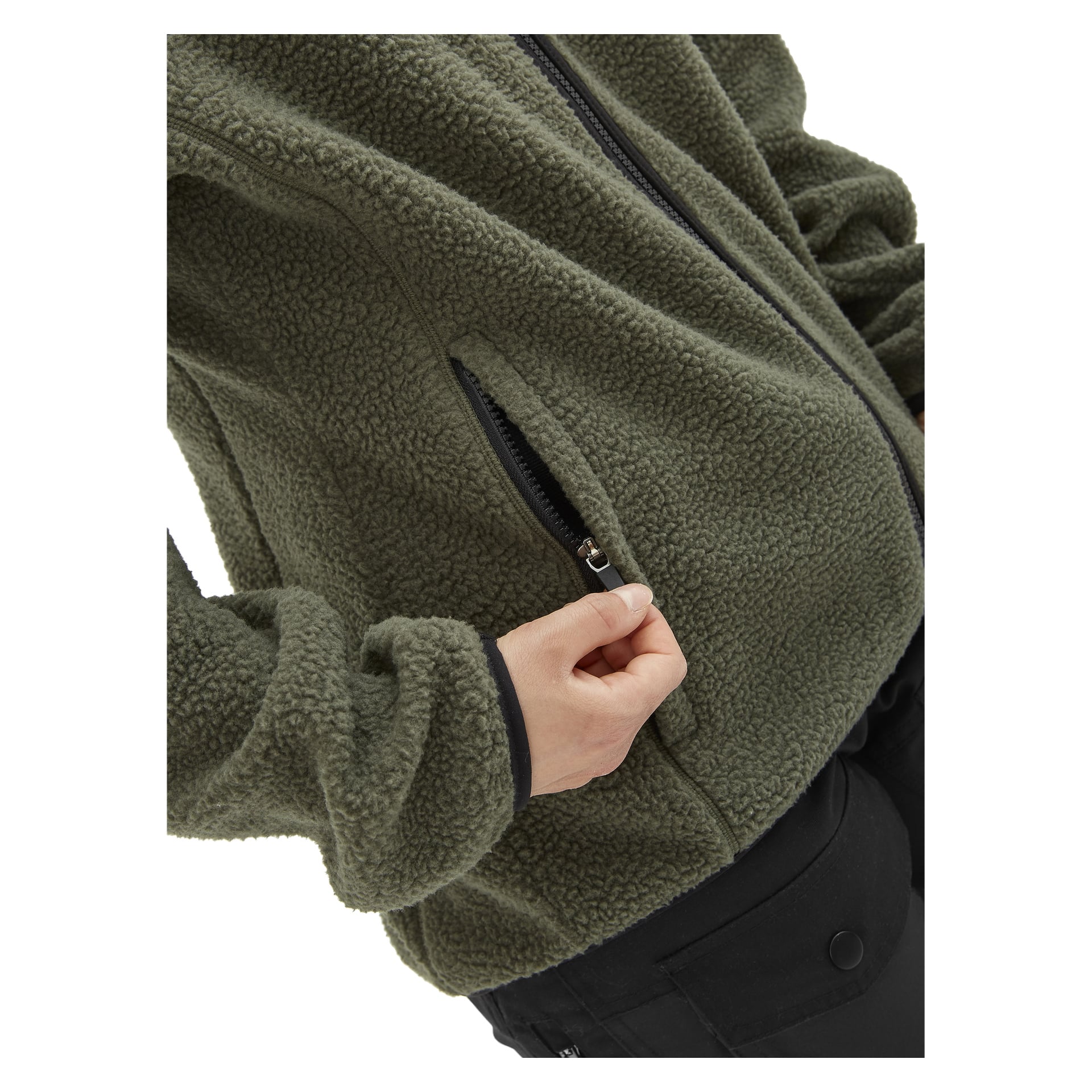Eine Frau, sichtbar vom Oberkörper abwärts, öffnet die Seitentasche einer grünen Fleecejacke von Kayoba Outdoor Woman, Ljusdal; Ihre Hand und ein Teil der Jacke sind im Fokus, was das Design der Tasche und das weiche Fleecematerial betont.