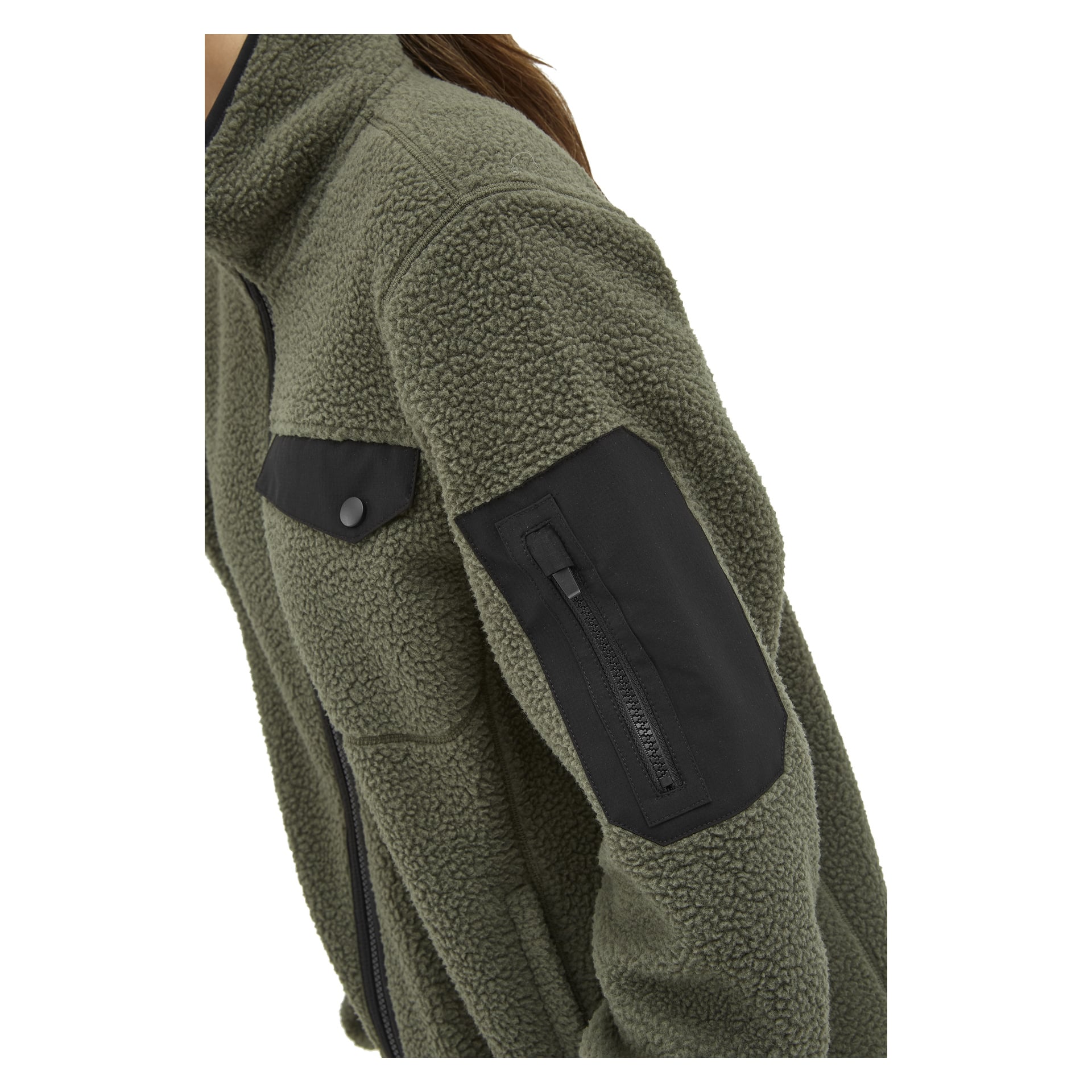 Lähikuva vihreästä Kayoba Outdoor Woman's fleece-takista Ljusdal, jossa näkyy musta vetoketjullinen tasku, jossa ylähihassa on läppä. Materiaali on teksturoitu ja sherpamainen. Taustalla näkyy osa henkilön päästä ja hänen ruskeat hiuksensa.