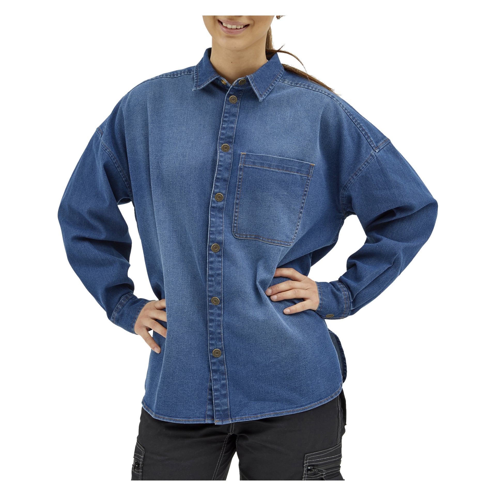 En kvinna står med händerna i sidan, ler och är klädd i svarta byxor och en damjeansskjorta från Jolene från Bluewear.