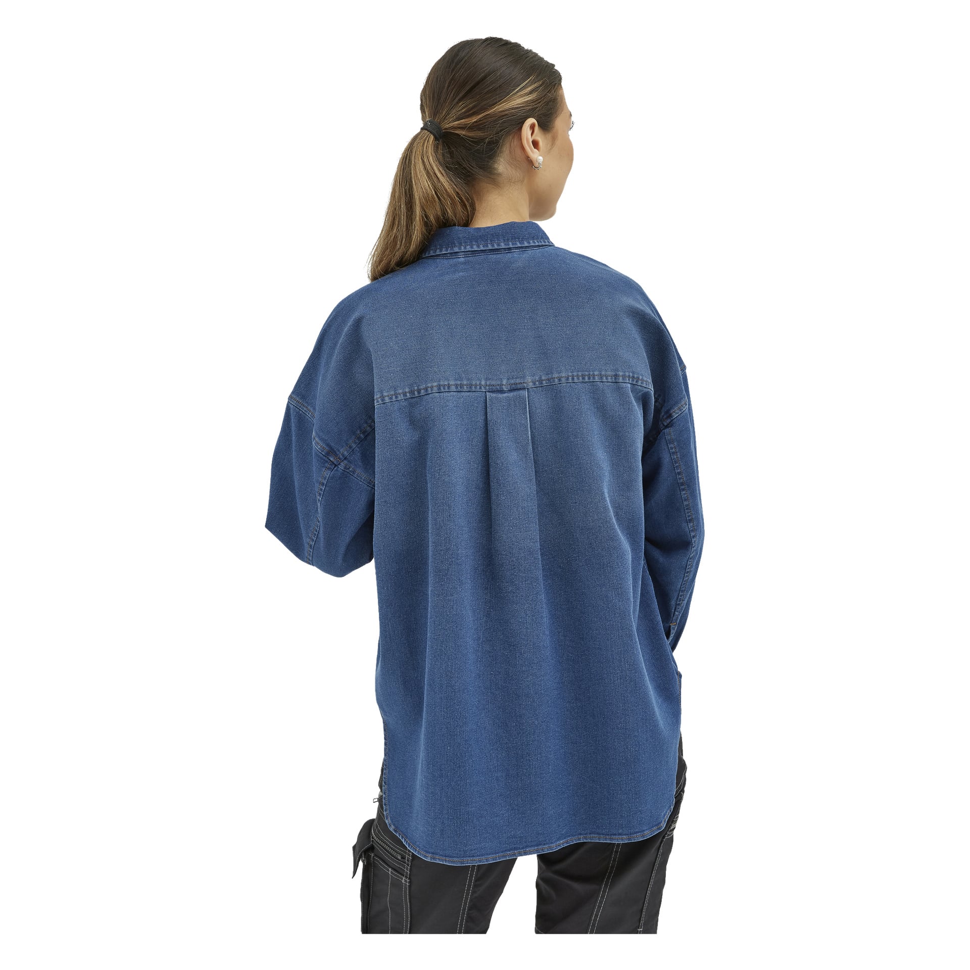 En person med långt hår uppsatt bakåt syns bakifrån, klädd i "Bluewear Women's denim shirt Jolene" med synliga sömdetaljer och ihopkommet svarta byxor.