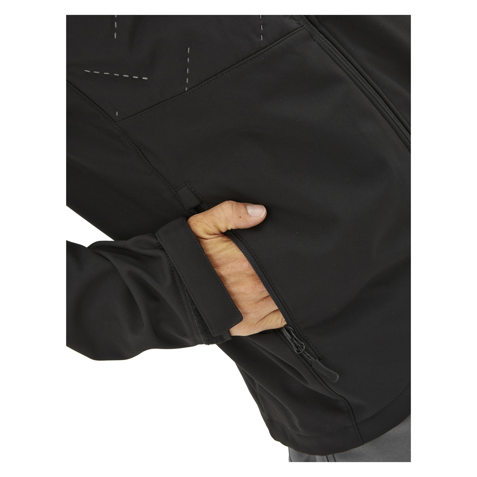 Någon bär Bluewear Lightly vadderade herrsoftshelljacka Jerry, med höger hand delvis nedstoppad i en dragkedjasförsedd sidoficka; endast deras bål, arm och hand syns.