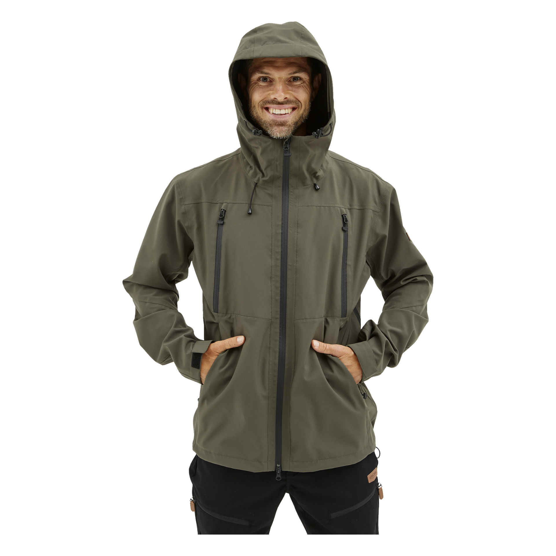 Någon visas vänd framåt, leende, och bär Kayoba Outdoor Men's Helag olivgrön skaljacka med huva och fyra fickor med dragkedja, båda händerna nedstoppade i framfickorna.
