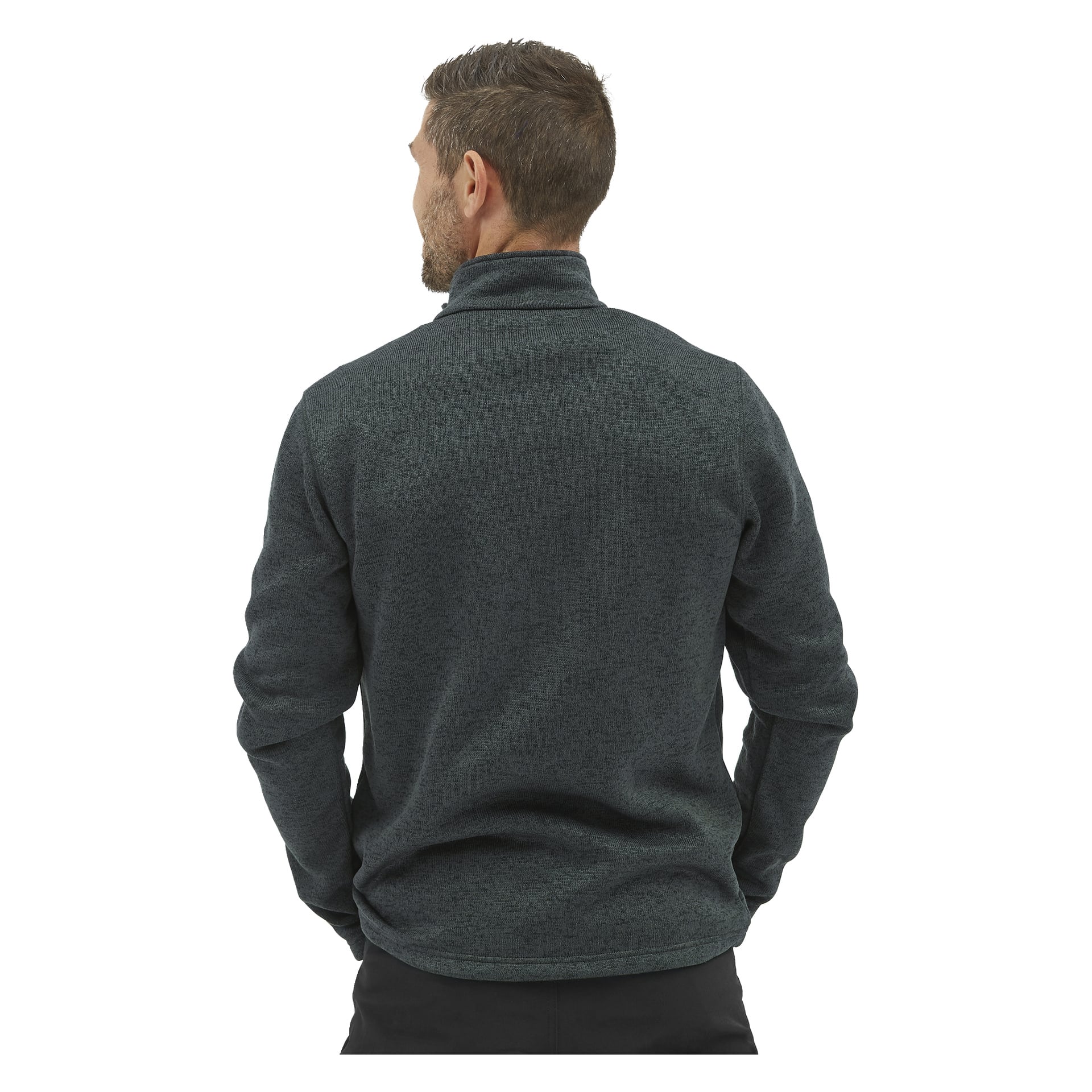 En man med kort brunt hår står med ryggen mot kameran, klädd i en mörkgrå Kayoba Outdoor Knitted herrjacka i fleece Malå och svarta byxor.