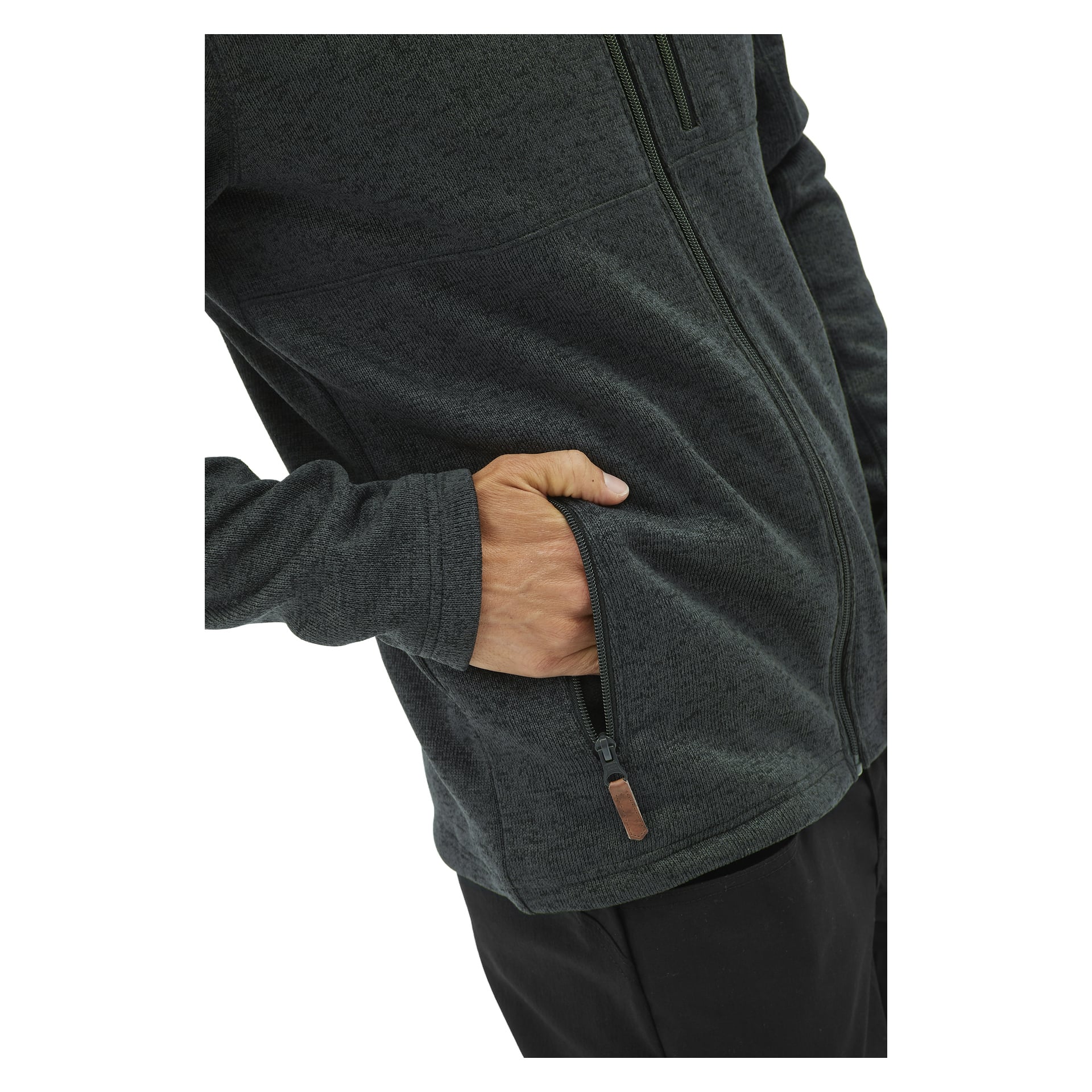 En person är avbildad från axel till mitten av låret iförd Kayoba Outdoor Knitted herrfleecejacka Malå i mörkgrått, med ena handen instucken i en dragkedjasförsedd sidoficka.