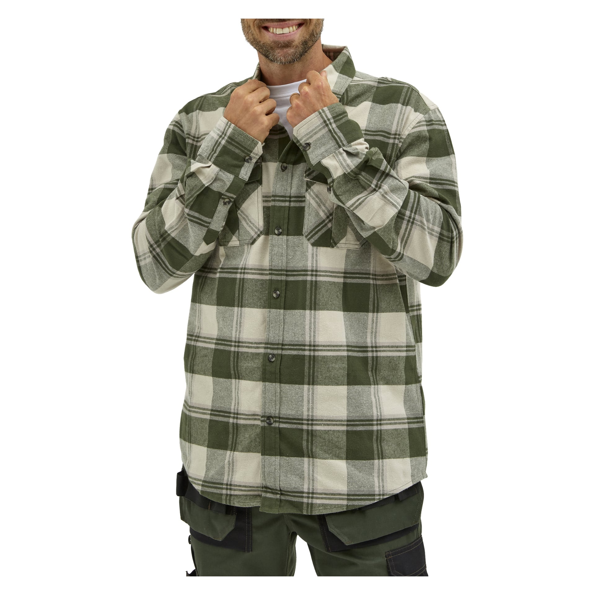 En man ler och håller kragen på sin "Men's flannel shirt Ture by Bluewear" i grönt och beige rutigt med båda händerna. Han visas från midjan och uppåt, iklädd en vit t-shirt under.
