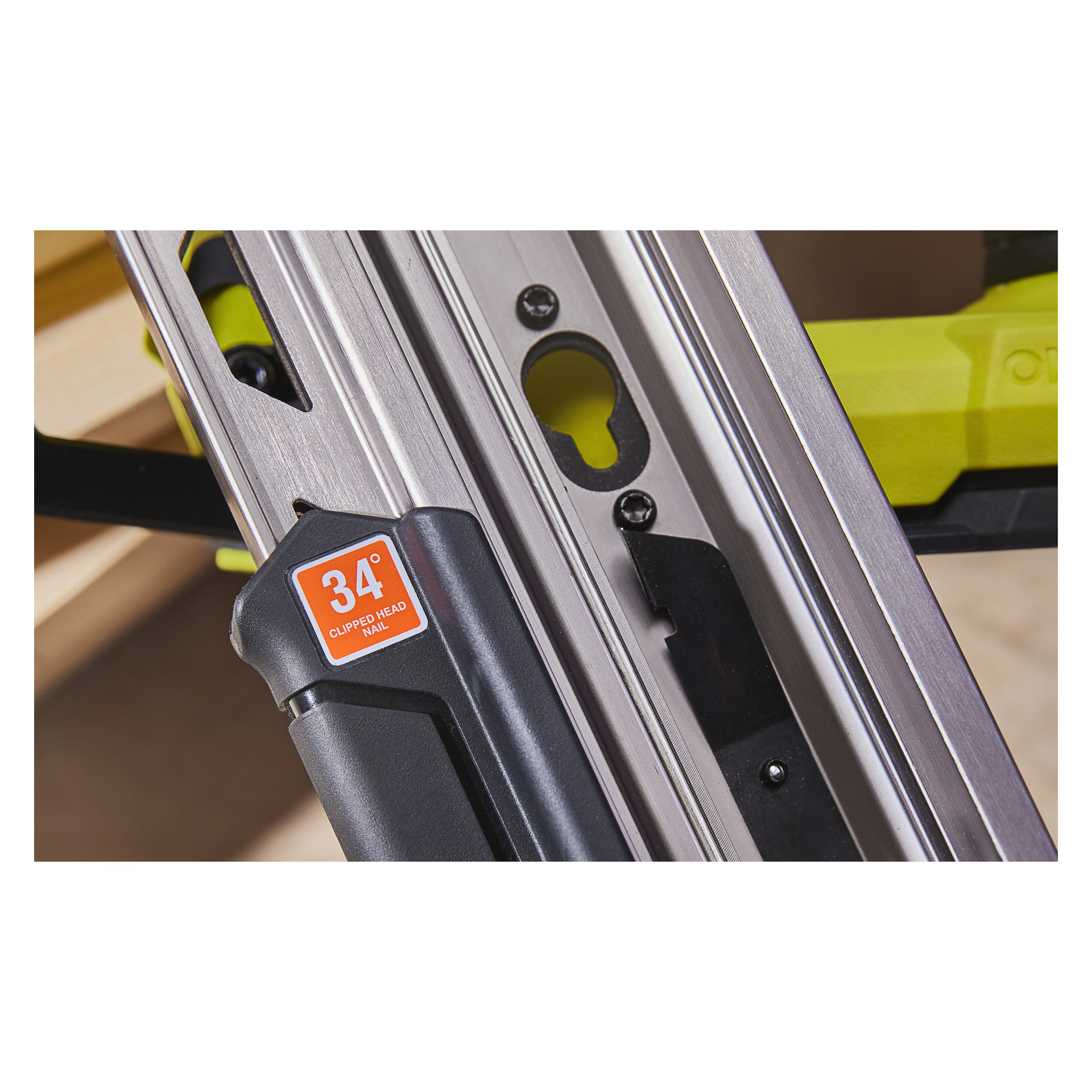 Yksityiskohtainen lähikuva Ryobi One+ HP -paristokäyttöisestä naulakivääristä RFN1834X-0, keskittyen naulalippaan ja oranssiin etikettiin, joka osoittaa 34 asteen kulman. Työkalussa on metallia ja muovia hopean, mustan ja vihreän sävyissä.