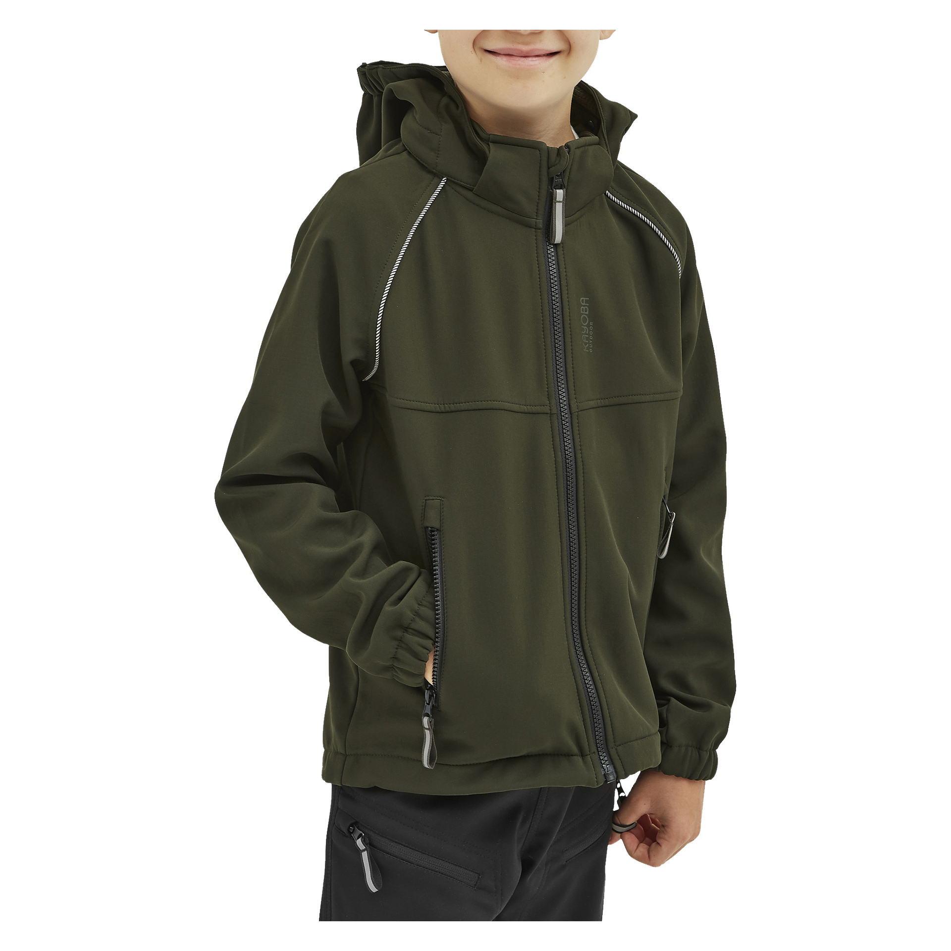 Uśmiechnięte dziecko stoi z jedną ręką w kieszeni, ubrane w oliwkowozieloną kurtkę Kayoba Outdoor Children's softshell Kramfors z kapturem i kieszeniami na zamek oraz czarne spodnie.