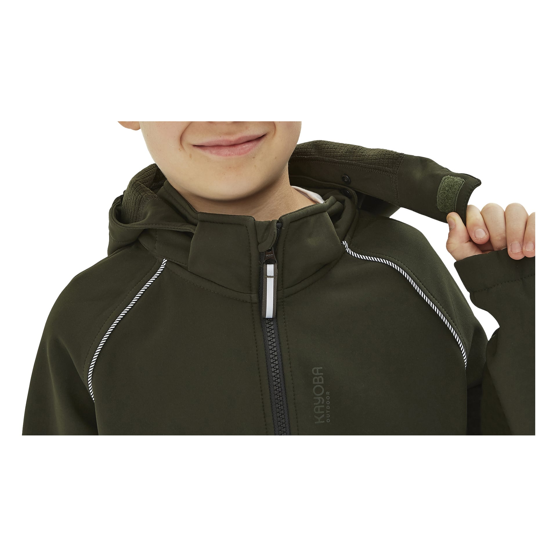 Dziecko ubrane w ciemnozieloną kurtkę Kayoba Outdoor Children's softshell Kramfors, która ma kaptur, białe odblaskające wykończenie, wyraźny zamek błyskawiczny i napis "KAYOBA" z przodu.