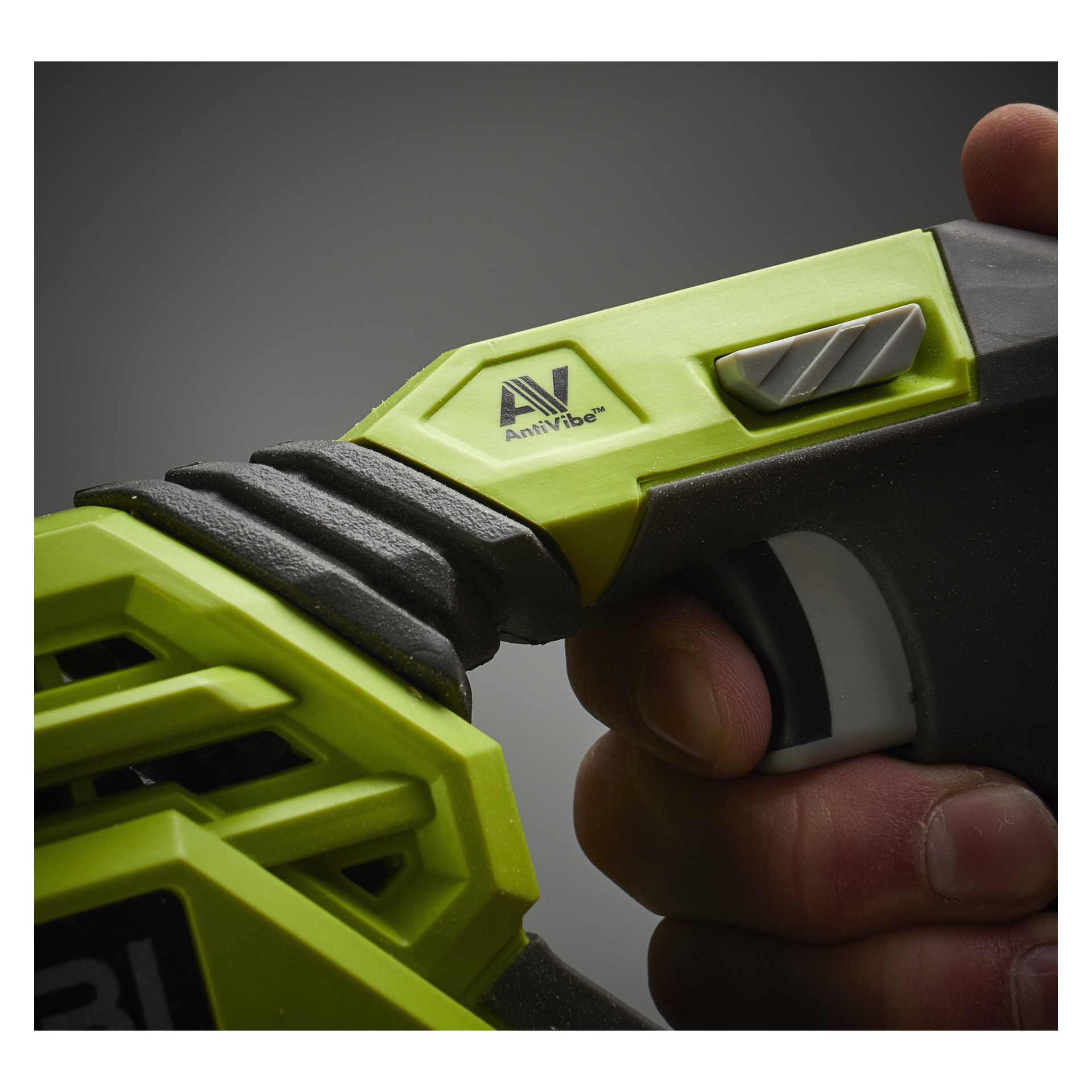 Eine Nahaufnahme einer Hand, die den grünen Griff eines batteriebetriebenen Ryobi One+ umschließt, zeigte R18RS-0. Ein silberner Schalter und ein "AV AntiVibe"-Logo sind deutlich sichtbar, mit einem verschwommenen grauen Hintergrund.