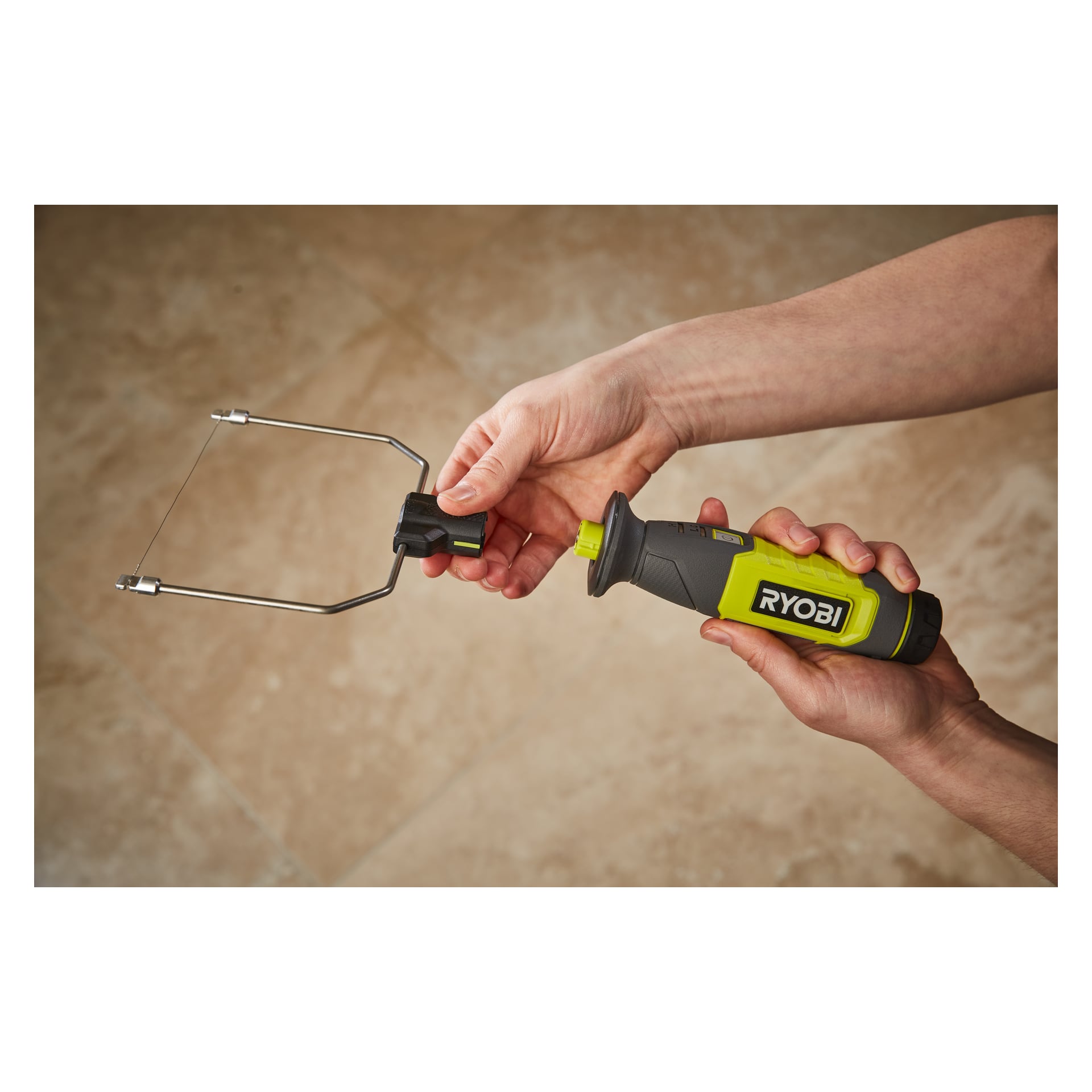 Noen holder en Ryobi USB Lithium Battery hot cutter RHC4-0, med et tynt trådblad, over beige gulvfliser.