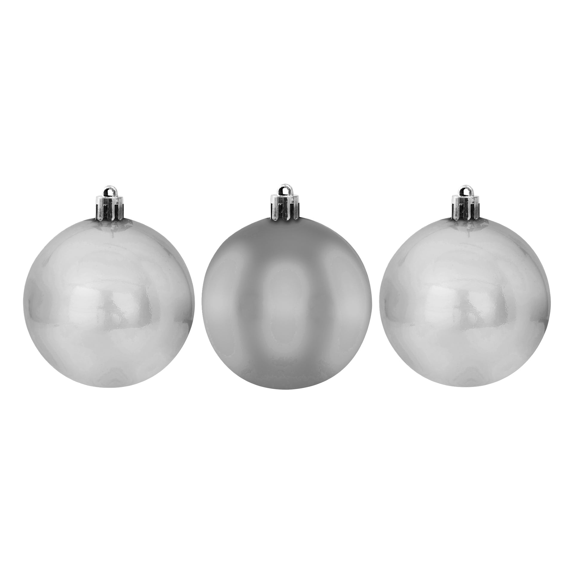 Tre blanka silverfärgade EKVIP julbollar, alla i samma storlek och form, placeras bredvid varandra med metallkorpor.