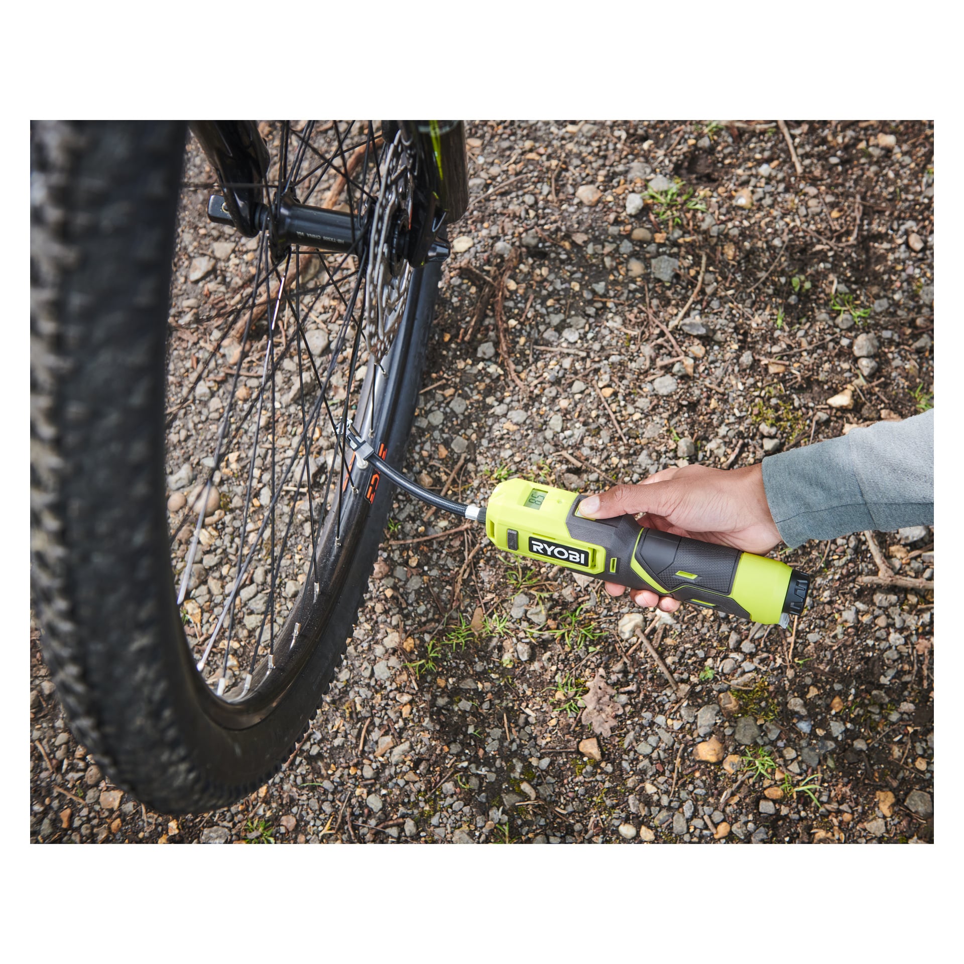 Noen bruker en Ryobi USB Lithium Battery mini-kompressor RI4-120G for å stramme bakhjulsbolten på en sykkel på grus.