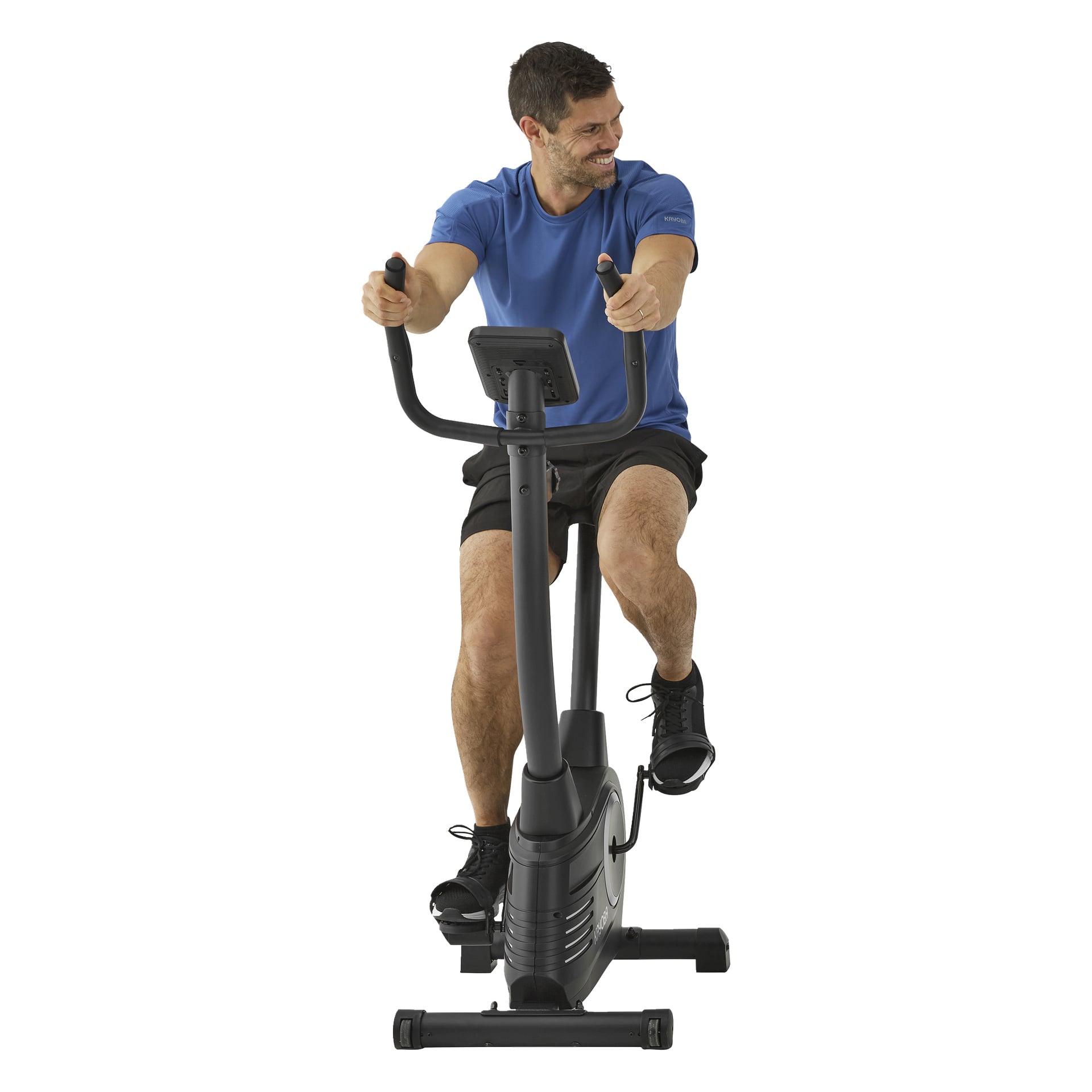 En man med kort hår i blå skjorta och svarta shorts ler medan han använder en Kayoba motionscykel med svart styr och display.