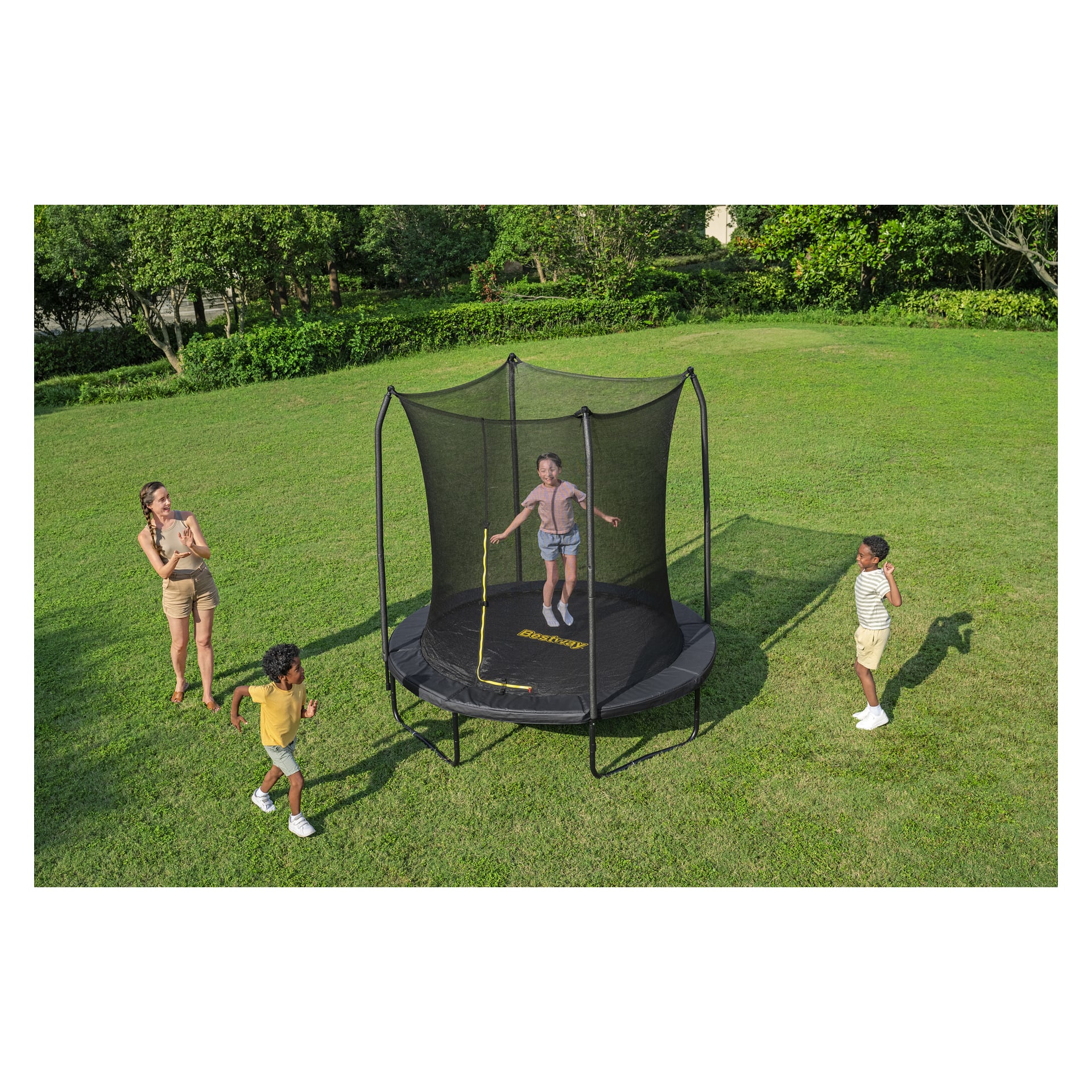 Lapsi hyppää Bestway Xtreme Air Trampoline 59119:n kyytiin nurmikkoisella pihalla, kun kaksi lasta ja aikuinen katsovat. Puita taustalla.