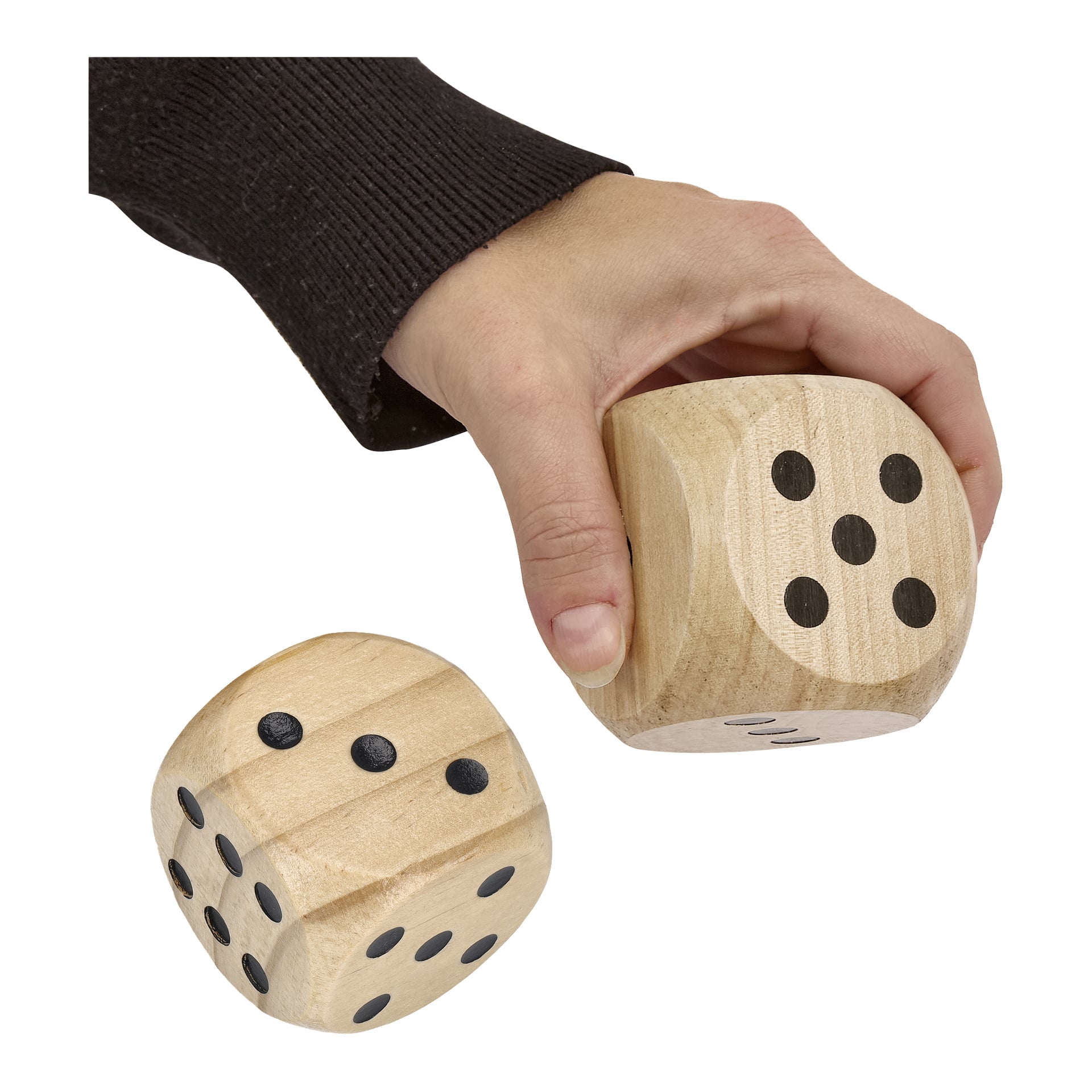 En hand håller i en stor trätärning från Kayoba Garden Yatzy-setet, med en annan matchande tärning placerad under.