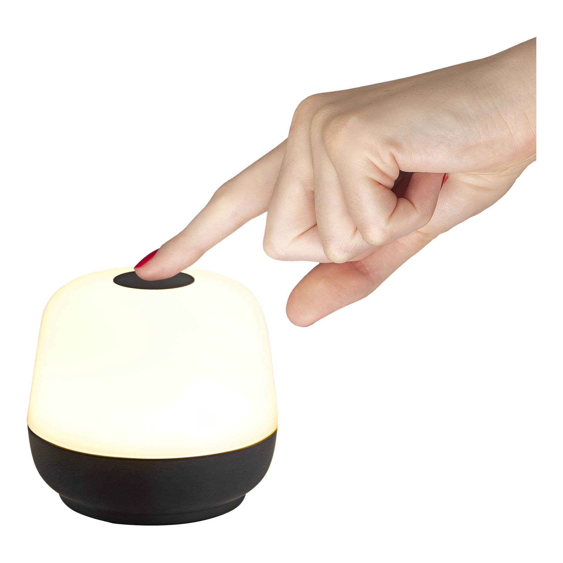 En hand med rött nagellack trycker på den översta knappen på en kompakt Anslut Portable-bordslampa, med svart bas och en lysande vit kupol.