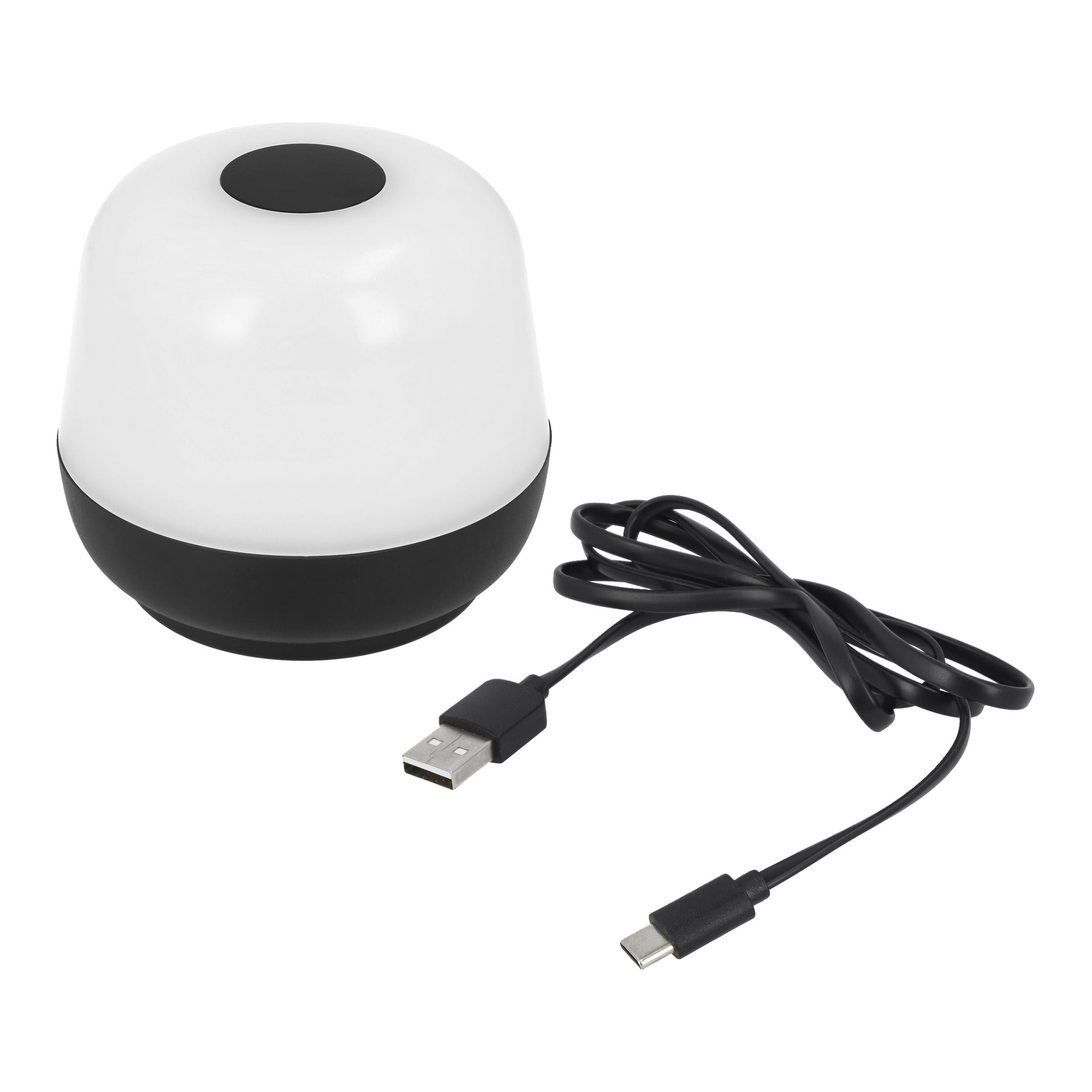 Den portabla bordslampan från Anslut är en kompakt, kupolformad LED-lampa med vit topp och svart sockel. Bredvid den ligger en svart USB-A till USB-C laddningskabel.