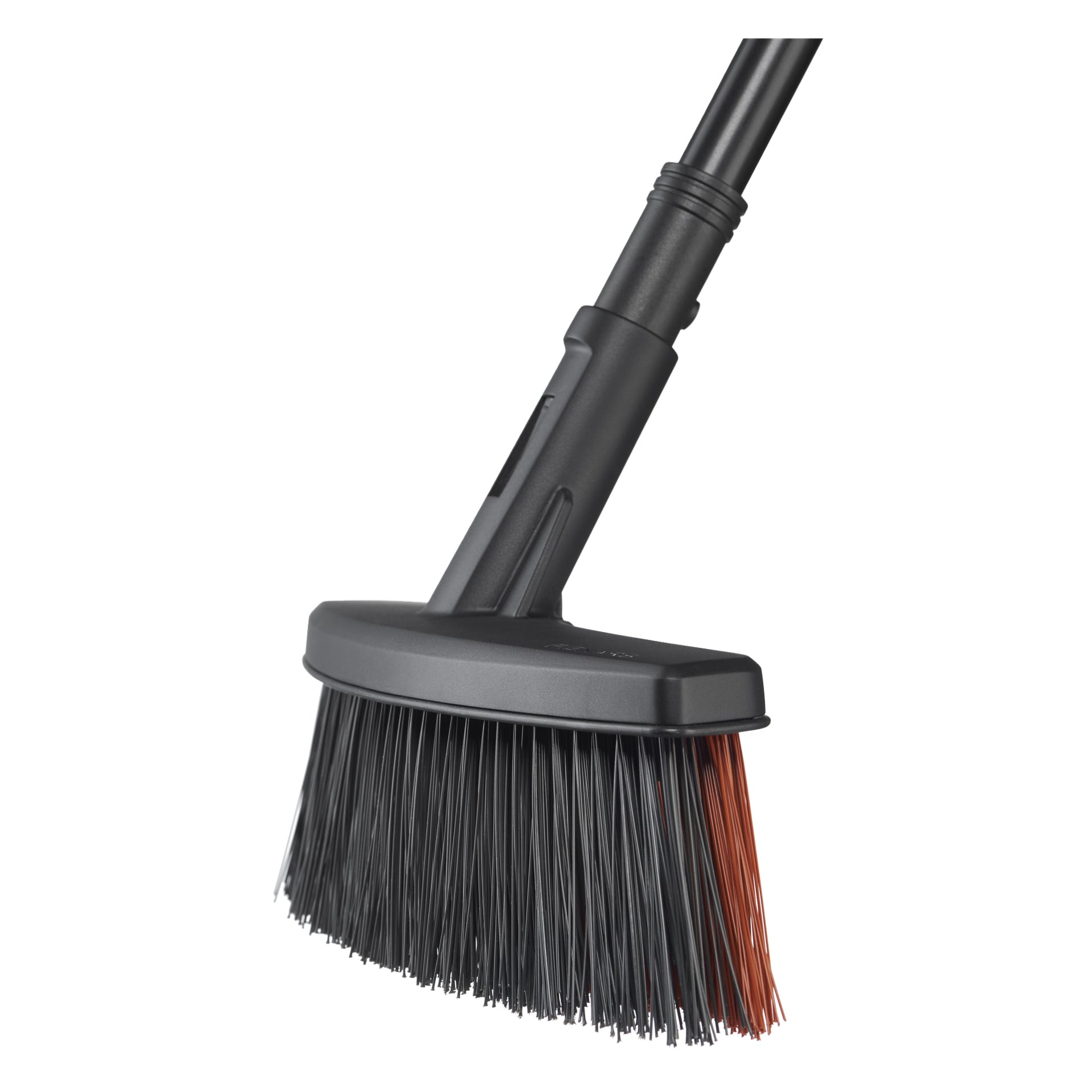 Närbild av Fiskars Kvast Solid M med mestadels svarta styva borst, ena sidan brun och ett svart handtag.