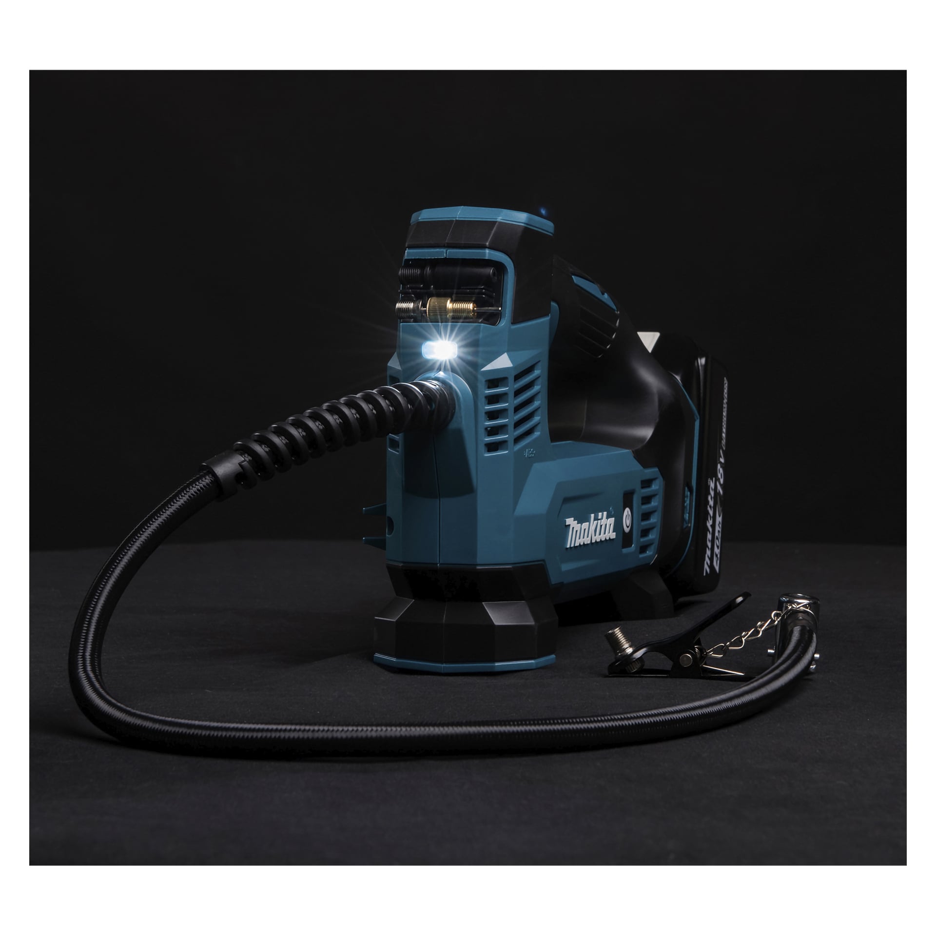Bezprzewodowy inflator Makita DMP180 z włączonym światłem LED, elastycznym wężem i tylnym akumulatorem, ustawiony na ciemnym tle.