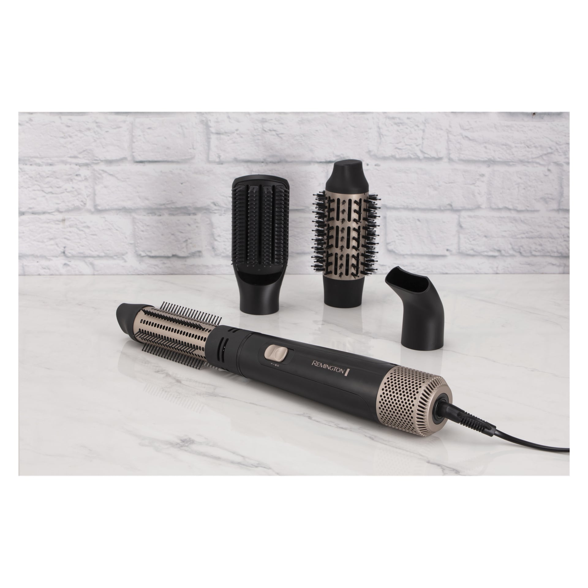 Remington Hot Air Brush Blow Dry & Style AS7500 i svart och silver med två borsthuvuden och ett koncentratormunstycke på marmor.