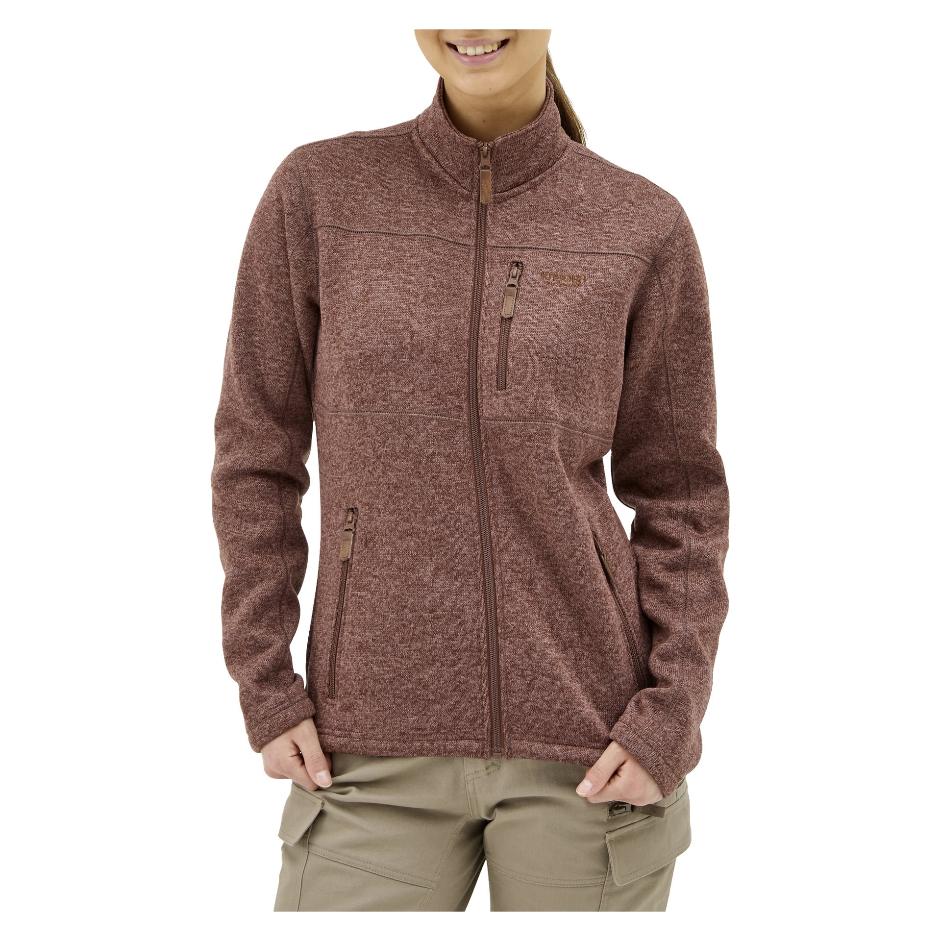 En person bär "Kayoba Outdoor Women's knitted fleece sweater MALÅ" i vinrött med beige byxor, stående med händerna i fickorna.