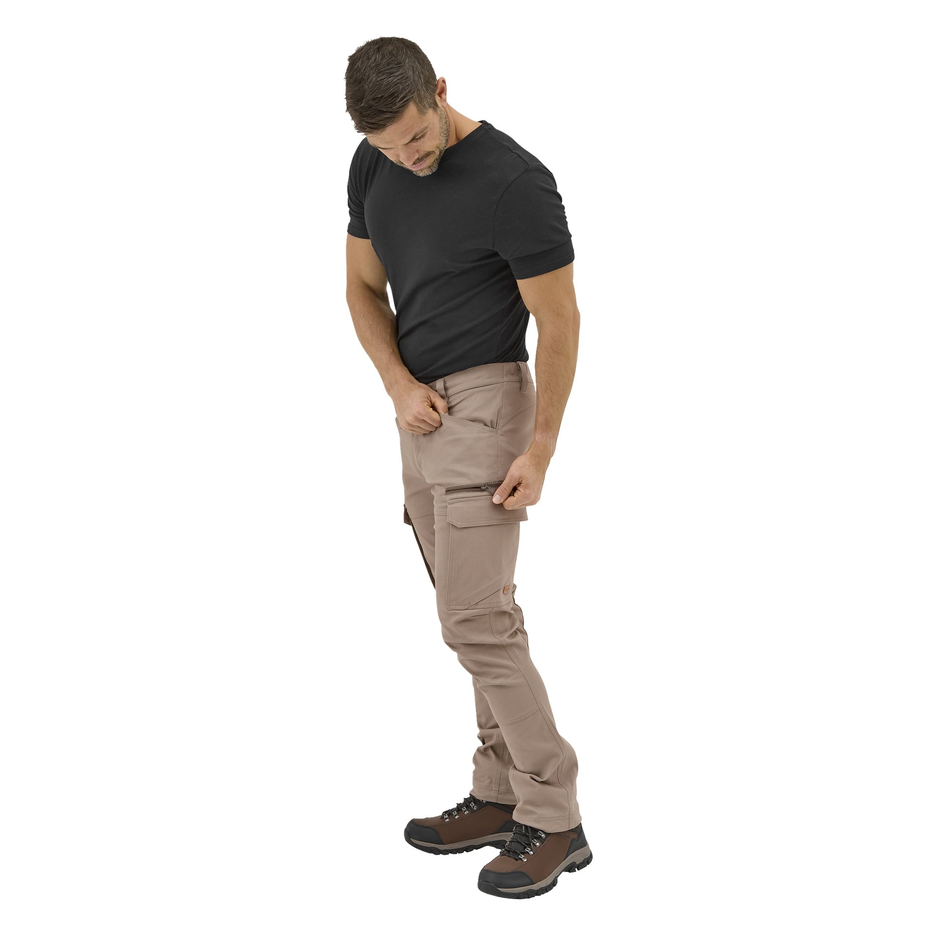Ein Mann in Kayoba Outdoor-Herrenhosen Åsen steht auf, öffnet eine Tasche seiner Hose und blickt auf seine Hände.