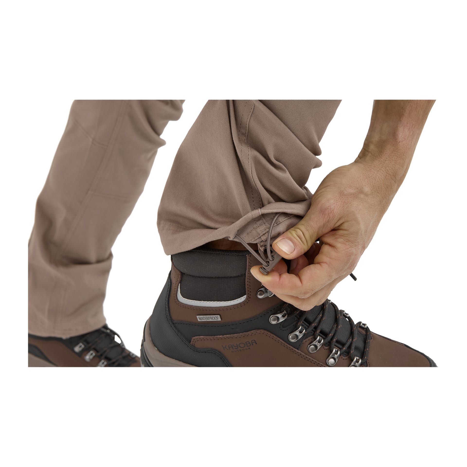 Jemand richtet die Kordelmanschette der Kayoba Outdoor Herrenhosen von Åsen über einem braunen und schwarzen Wanderschuh.