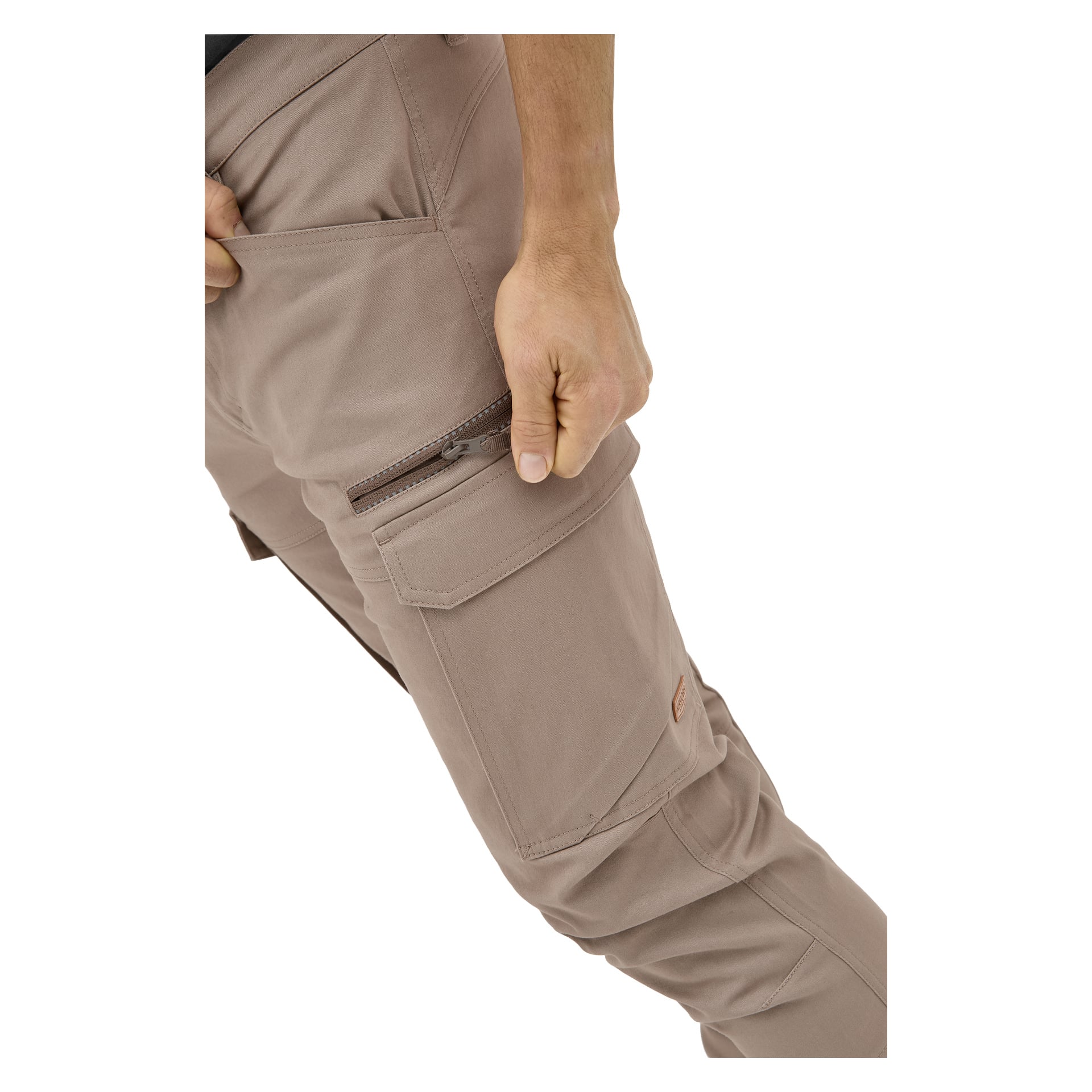Eine Person in Kayoba Outdoor Herrenhosen aus Åsen hält den Reißverschluss einer Oberschenkeltasche und konzentriert sich auf die Hose sowie teilweise auf Arm und Hand.
