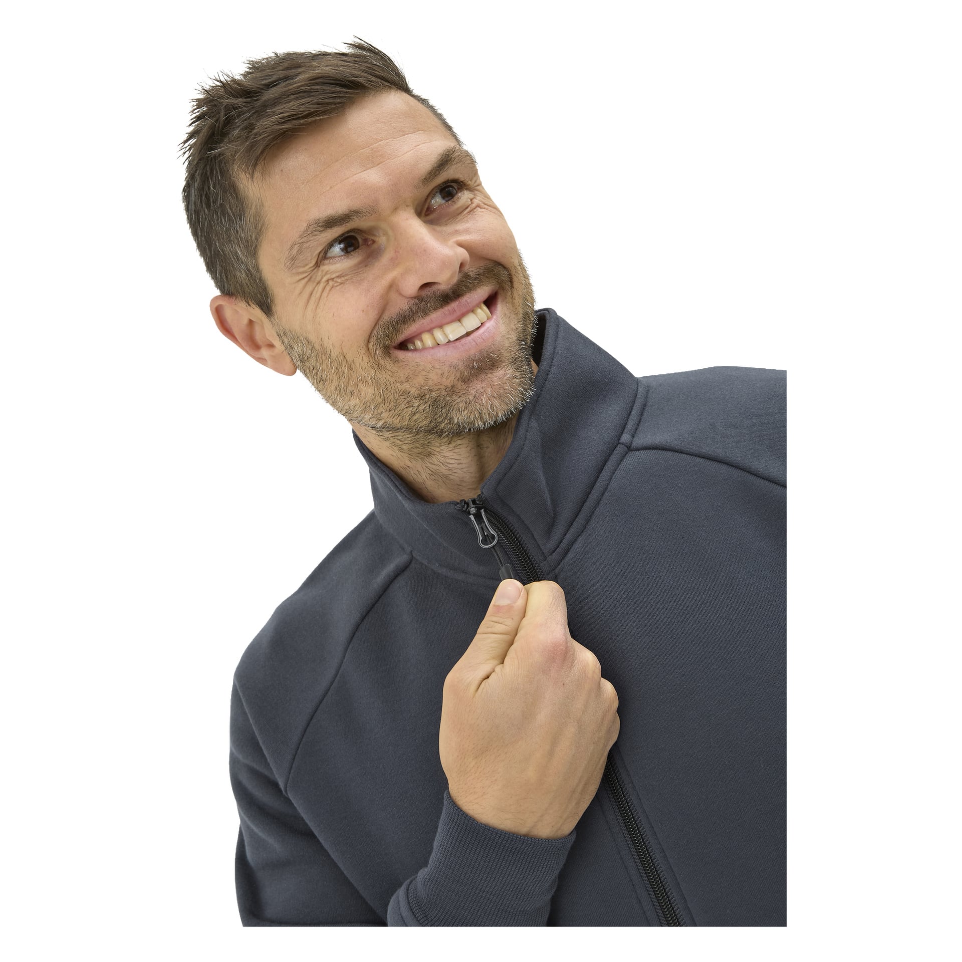 Mannen med kort brunt hår och stubb ler och tittar upp medan han drar upp dragkedjan på en mörkgrå tröja där det står "Bluewear Men's sweater Atlas".