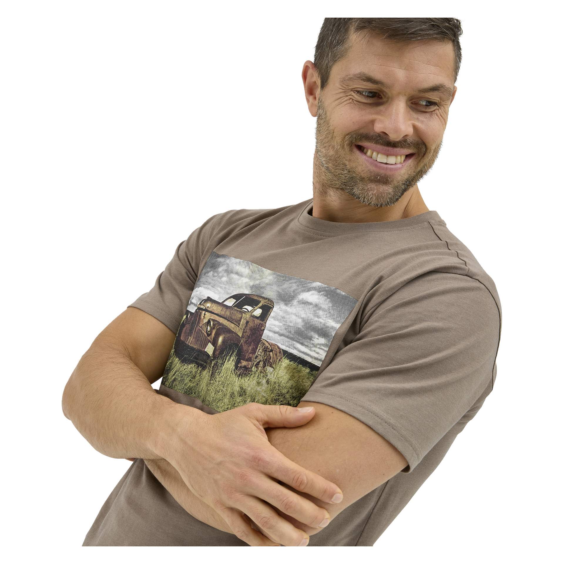 Smilende mann med kort hår og skjegg, armene i kors, har på seg Bluewear Sebbe T-skjorte med en gammel lastebil i et gresskledd feltmønster.