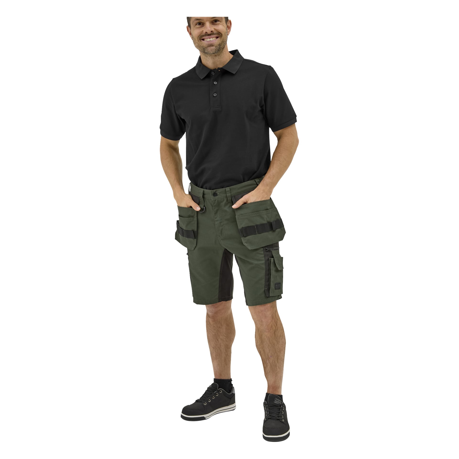 En leende man bär en svart Bluewear Putte-pikétröja, gröna cargoshorts med fickor och svarta sneakers med vita sulor.