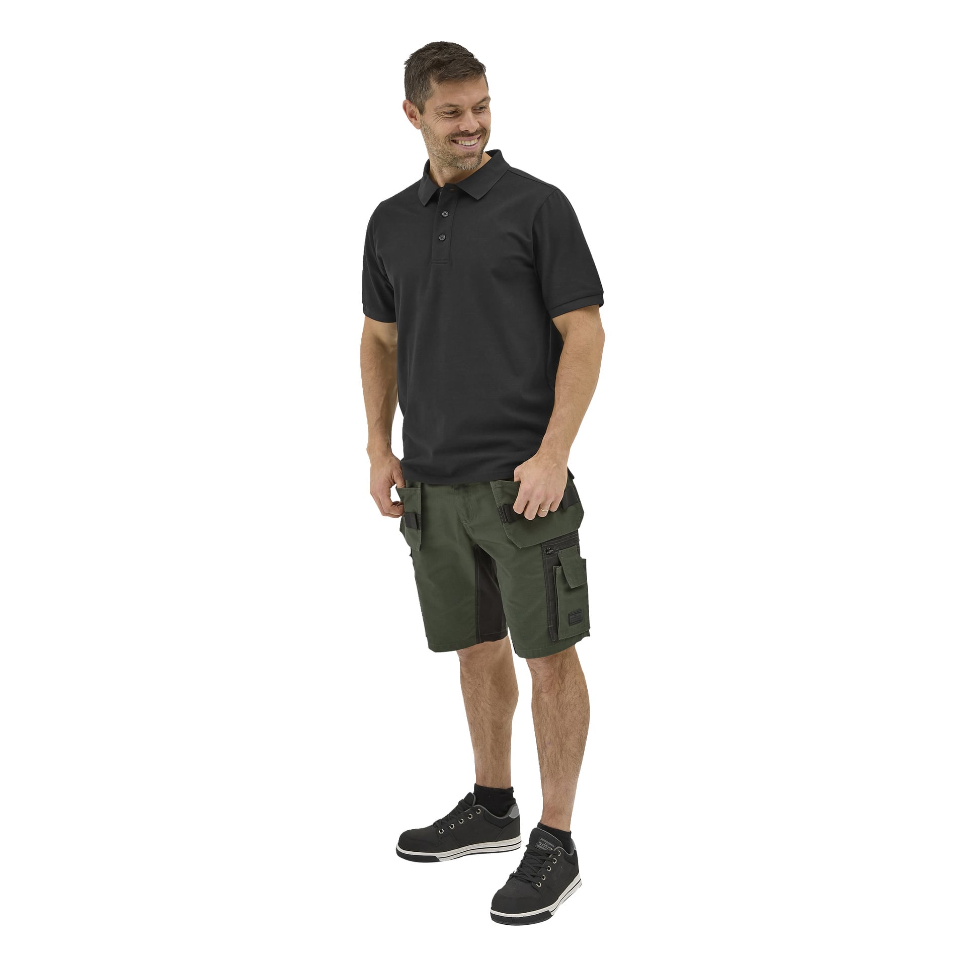 Leende man i svart Bluewear Putte-pikétröja, gröna cargoshorts med fickor och svarta sneakers med vita sulor, som tittar åt höger.