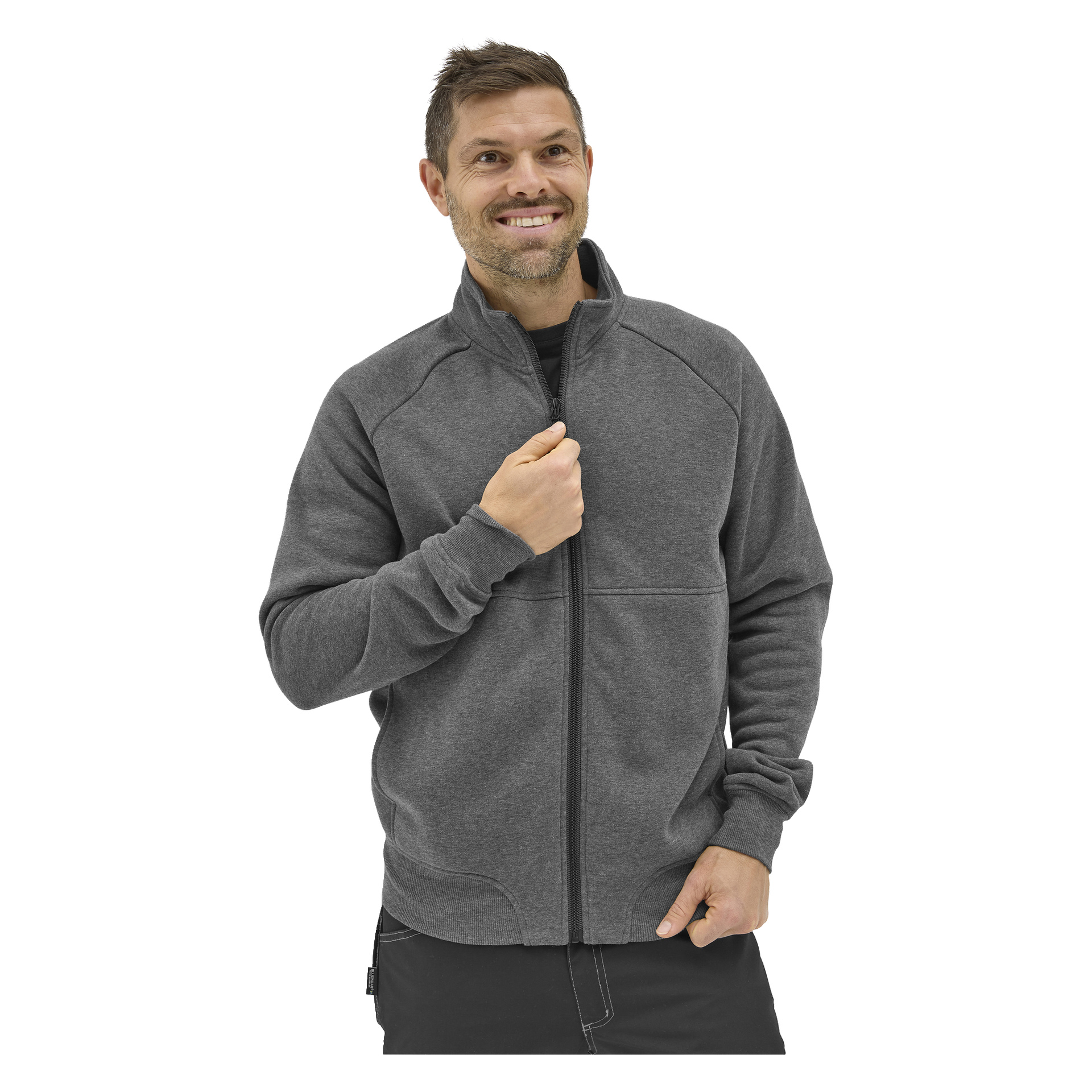 En leende man med kort hår och skägg bär en grå Bluewear Atlas fleece med dragkedja över en svart skjorta och håller dragkedjan nära bröstet.